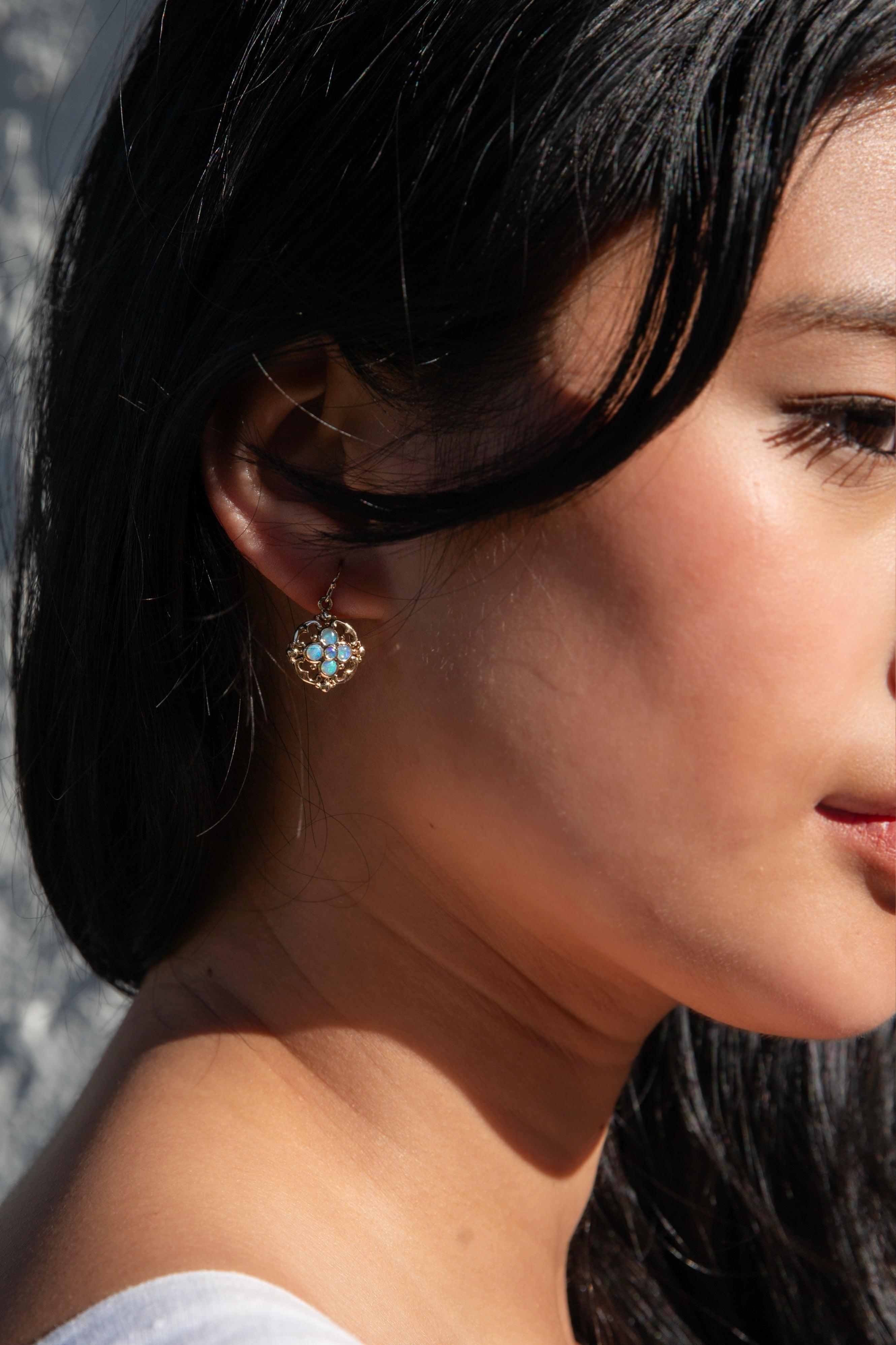 Her opals are set in gold frames of hearts and flowers, illustrative of the profound and sweet fragility that is the beginnings of new love.

The Faye Earrings Gem Details
The round solid Australian crystal opal cabochons display blue, green and