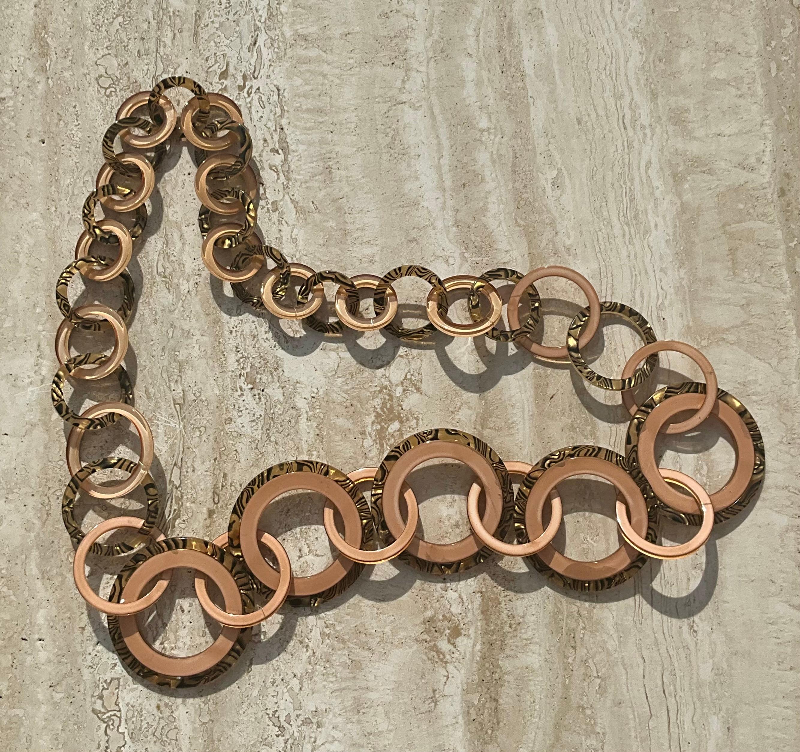 Questa cintura Vintage a cerchi intrecciati offre un mix senza tempo di design classico ed eleganza moderna. Caratterizzata da una serie di maglie circolari lucide e intrecciate, questa cintura è un'aggiunta versatile a qualsiasi guardaroba. Il