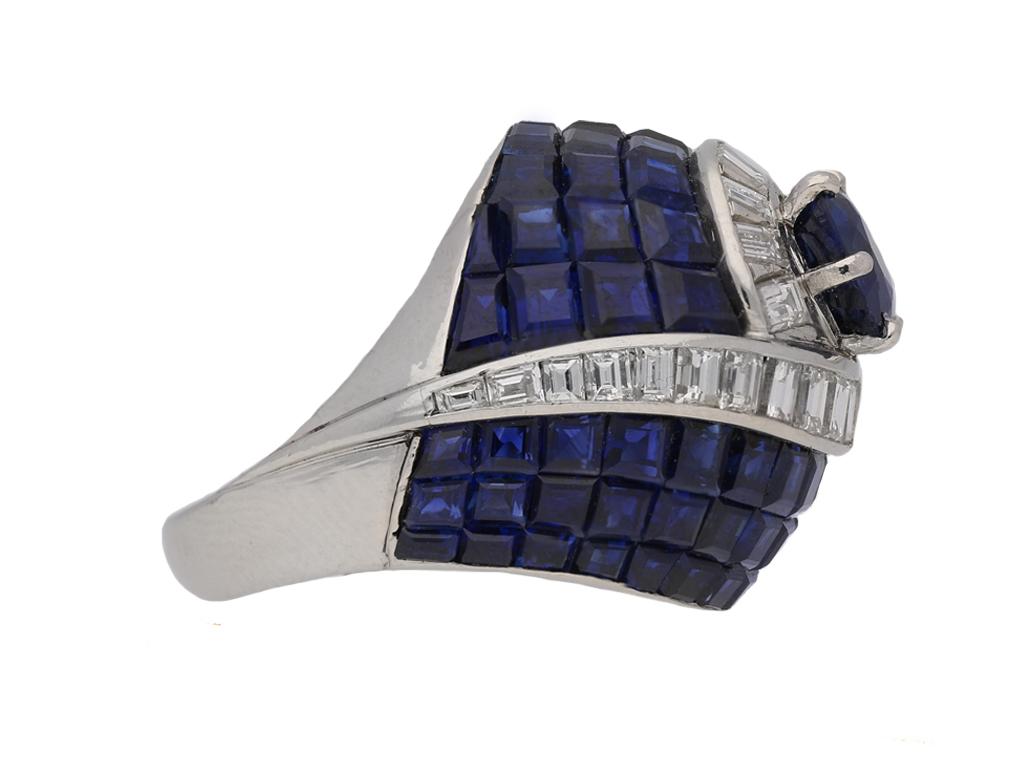 Vintage invisibly set sapphire and diamond ring. Centrally set with a cushion shape old cut natural unenhanced sapphire in an open back claw setting with a weight of 2.00 carats, surrounded by seventy six rectangular baguette cut natural unenhanced