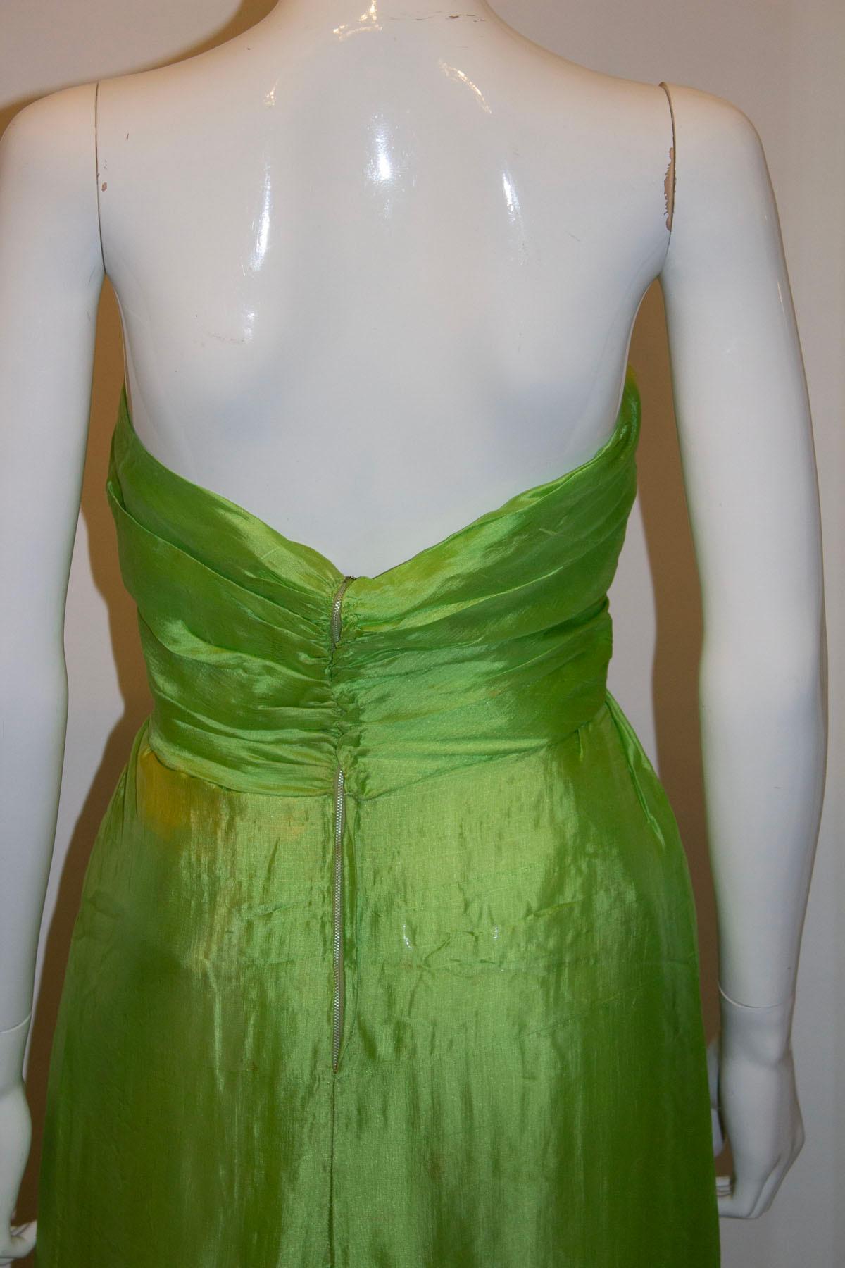 A stunning vintage couture gown and jacket by the famous Italian designer Irene Galitzine. The gown is strapless in a vibrant green colour with boning and a back zip. The dress is lined in silk, and has weights in the hem.
The jacket is green with 