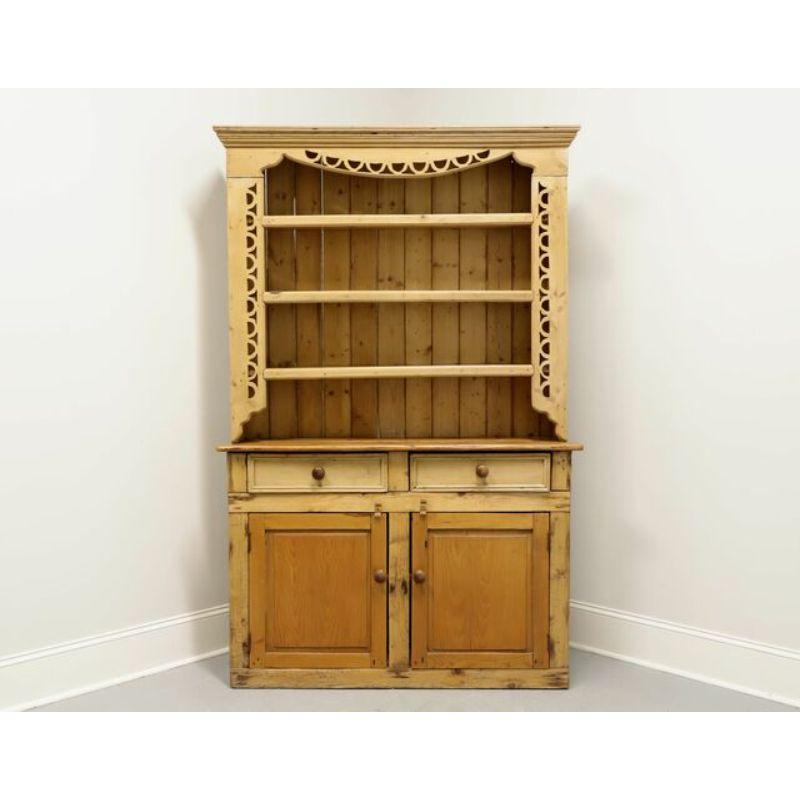 A benchmade Farmhouse style hutch. One piece construction made from solid reclaimed pine. Upper portion is topped by crown molding, has three open shelves, top shelf having a plate holder, and decorative carving to top & sides. Lower portion has