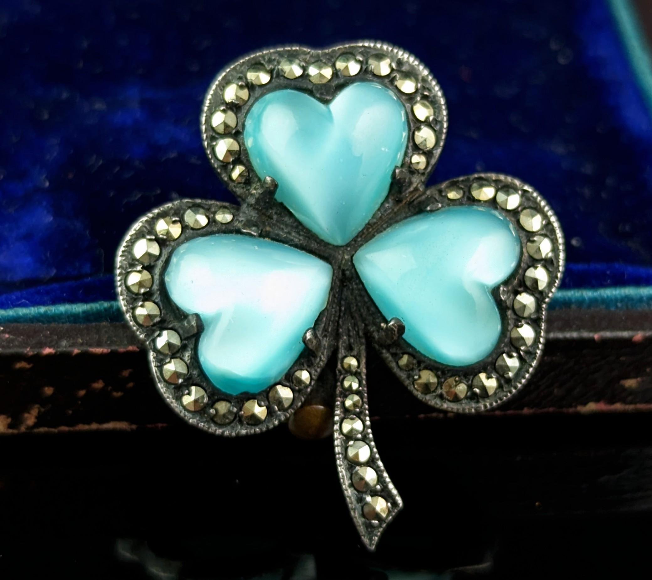 A gorgeous vintage Irish shamrock brooch.

This is such a beautiful piece with the lovely pearlised opaque blue paste cabs set into the front, these cabochons make up the leaves of the shamrock, they are chunky and smooth with a greeny blue