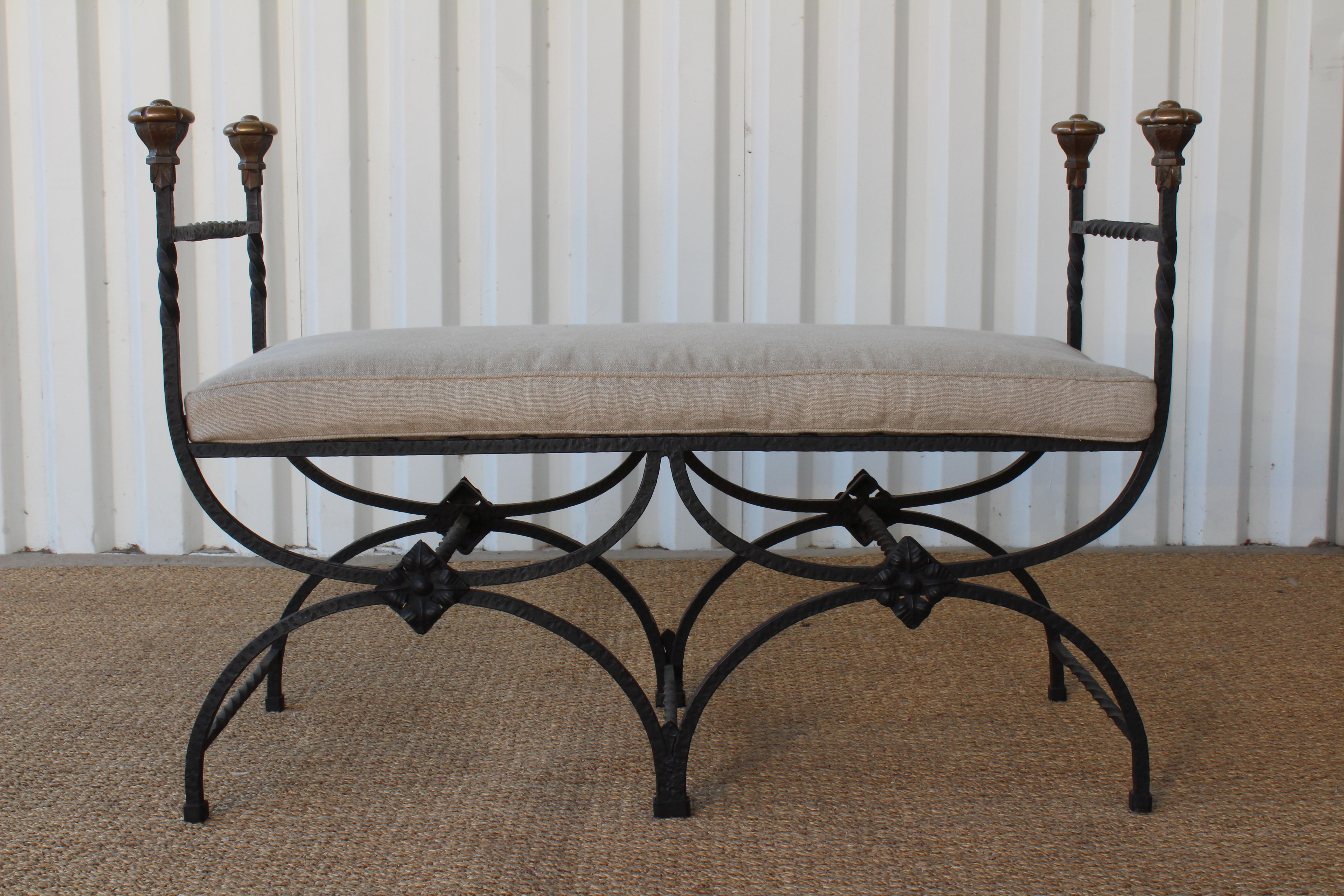 Vintage Savonarola bench made of heavy forged iron with bronze finials. In excellent condition with a new cushion upholstered in Belgian linen.