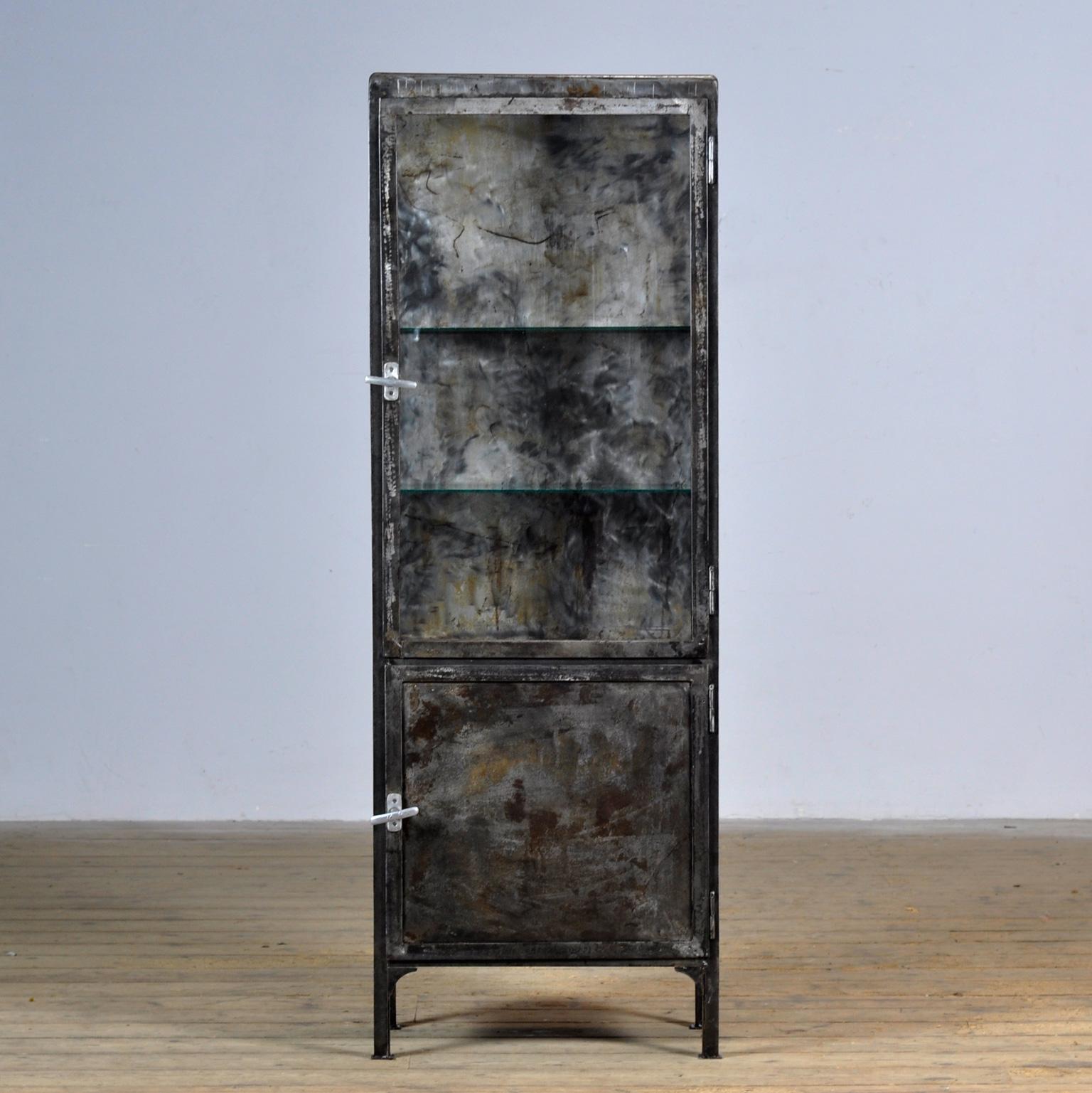 Medical cabinet made of iron and glass. The cabinet is from the 1950s and was produced in Hungary. The cabinet is stripped down to the metal and finished with a transparent lacquer. The cabinet comes with 2 glass shelves.