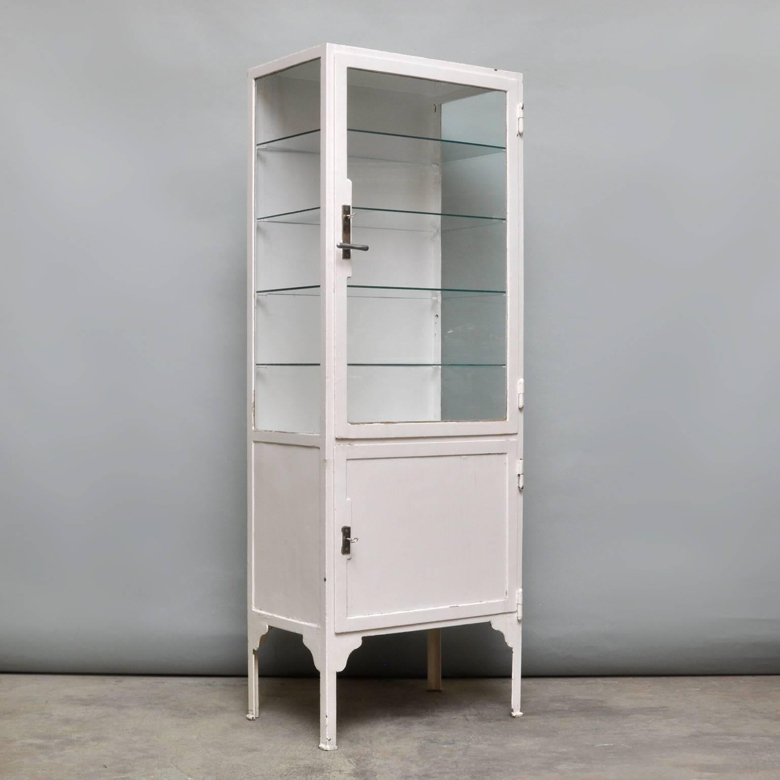 This medicine cabinet was produced in the 1940s in Hungary. Made of thick iron and antique glass. It features four glass shelves. Heavy quality.