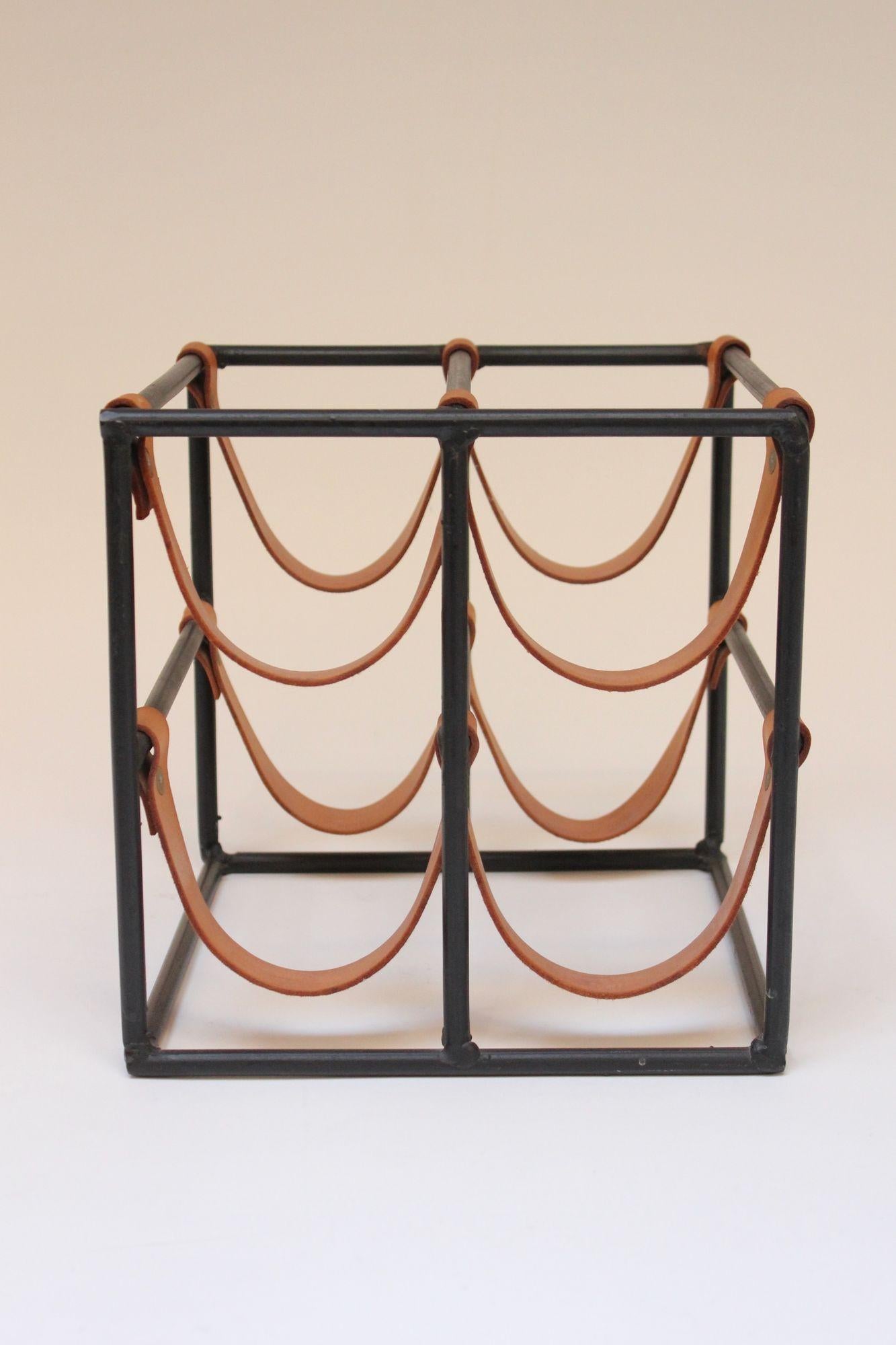 Mid-Century American Modern wine rack by Arthur Umanoff for Shaver Howard composed of eight saddle-leather strap holders and wrought iron frame. All original condition, appearing to be barely used, as leather is in excellent, vintage