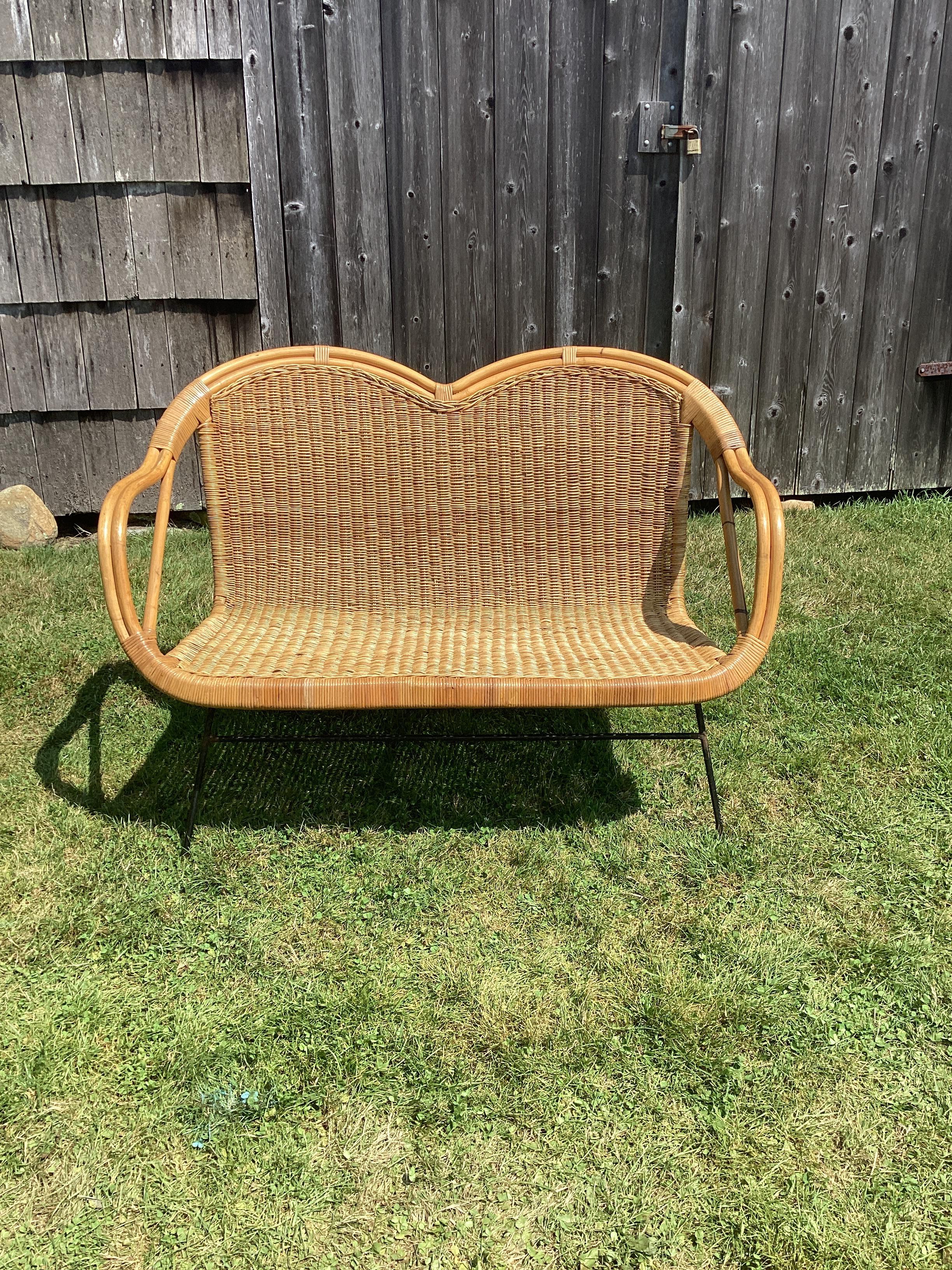 A woven wicker settee with an iron frame. This settee was manufactured in British Hong Kong dating them to middle of the 20th Century. 
We have a matching pair and is listed separately. Both sets are in good condition with minor wicker losses.