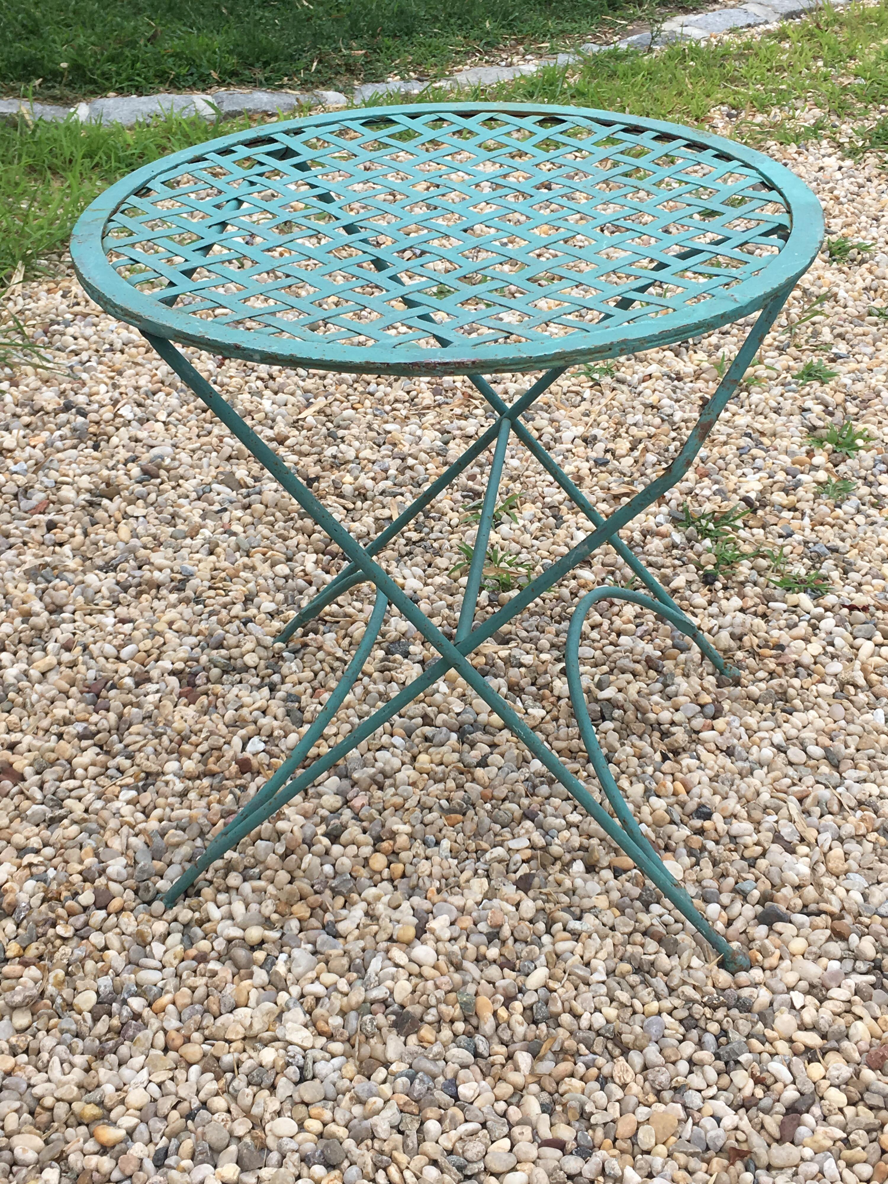 Vintage iron Bistro table with basket weave top in teal finish.

Some rust coming through finish.

Piece folds down. Can be shipped.