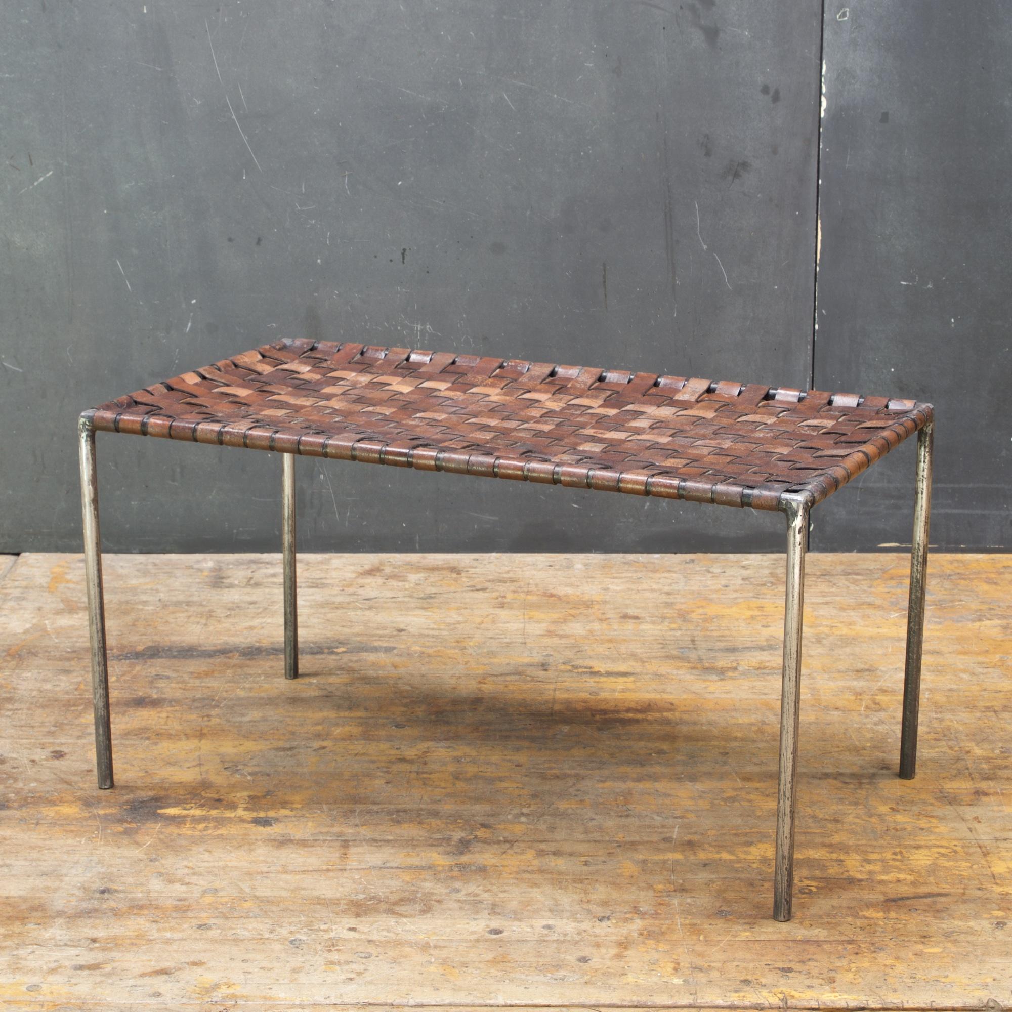 This piece is In the manner of Swift and Monell designed furniture. Beautifully patinated mid-century bench with a semi-polished welded iron/steel rod frame, with lattice woven webbed leather strapping.