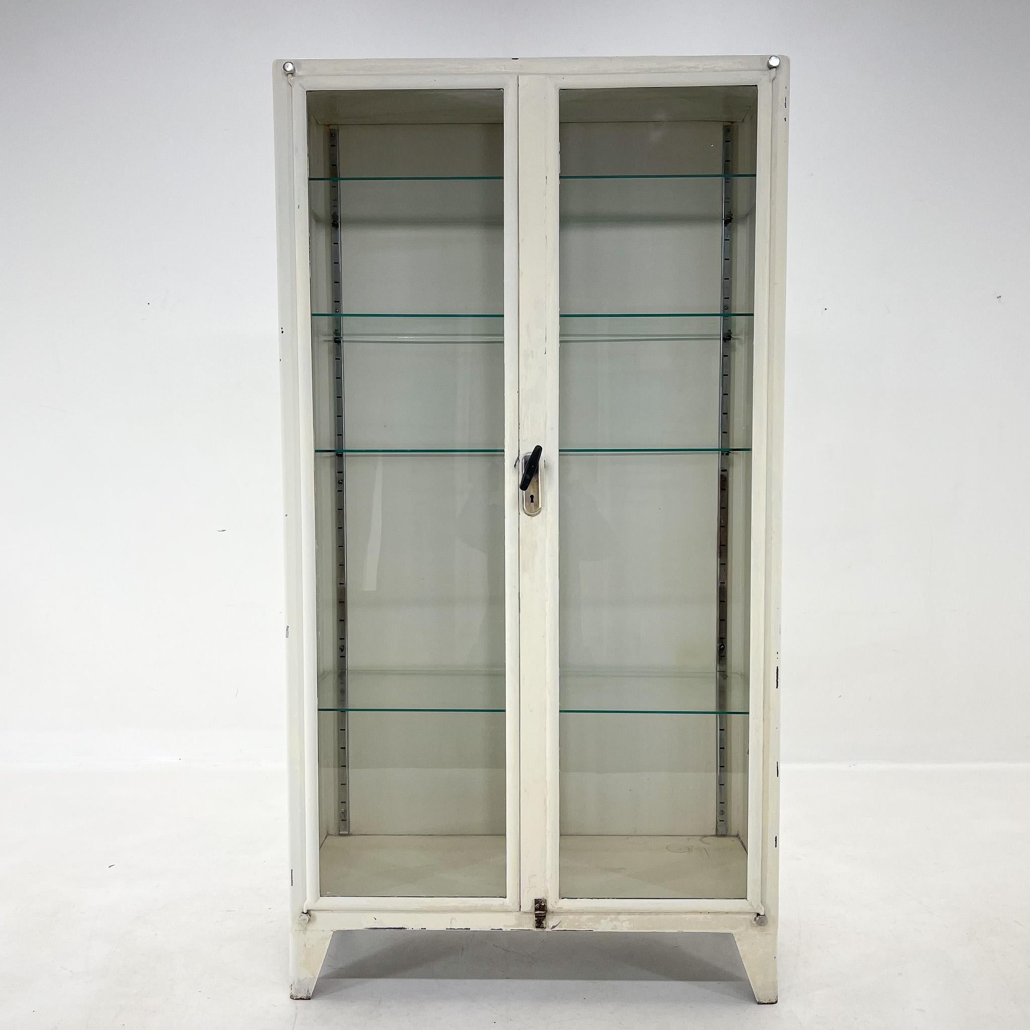 Very nice vintage iron and glass medical display cabinet. It has some signs of use (see photo). Made in the 1950's in former Czechoslovakia. Original locking system.