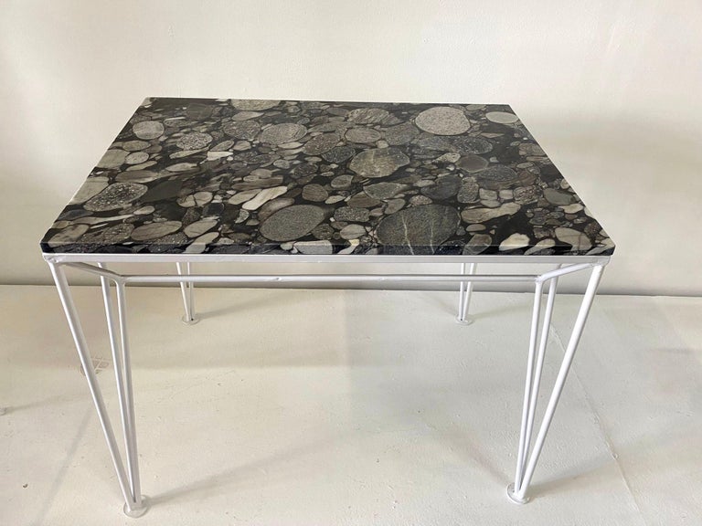 Rare encrustations within a natural black marble top - this stylish white powder-coated table with sleek lines.