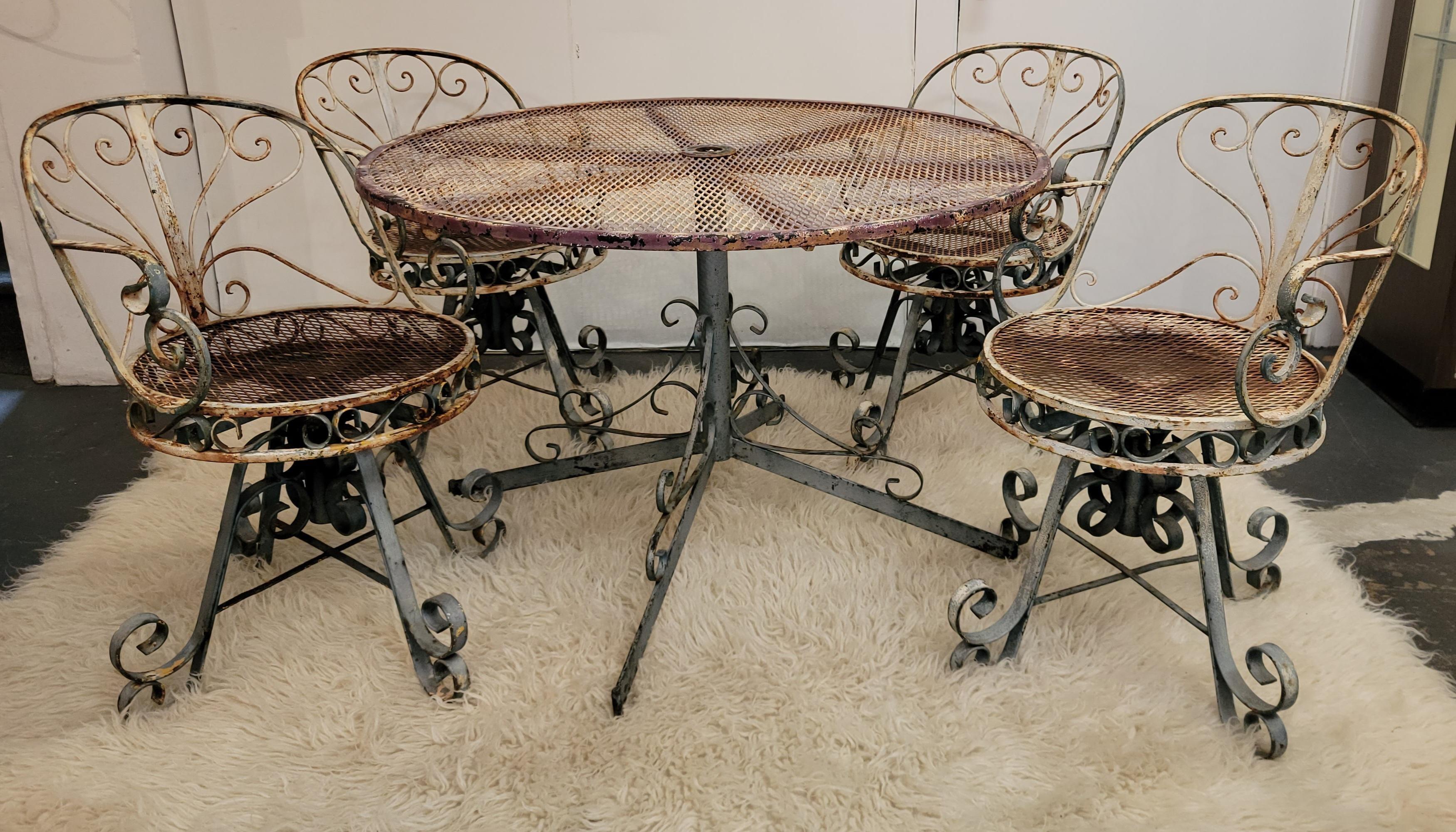 Five-piece outdoor garden set, four iron chairs and iron table. The chairs and tale have all original paint and amazing patina. The chairs swivel in place. One of the chairs does not swivel.

Table measures -42 inches diameter x 28.5 high
Chairs