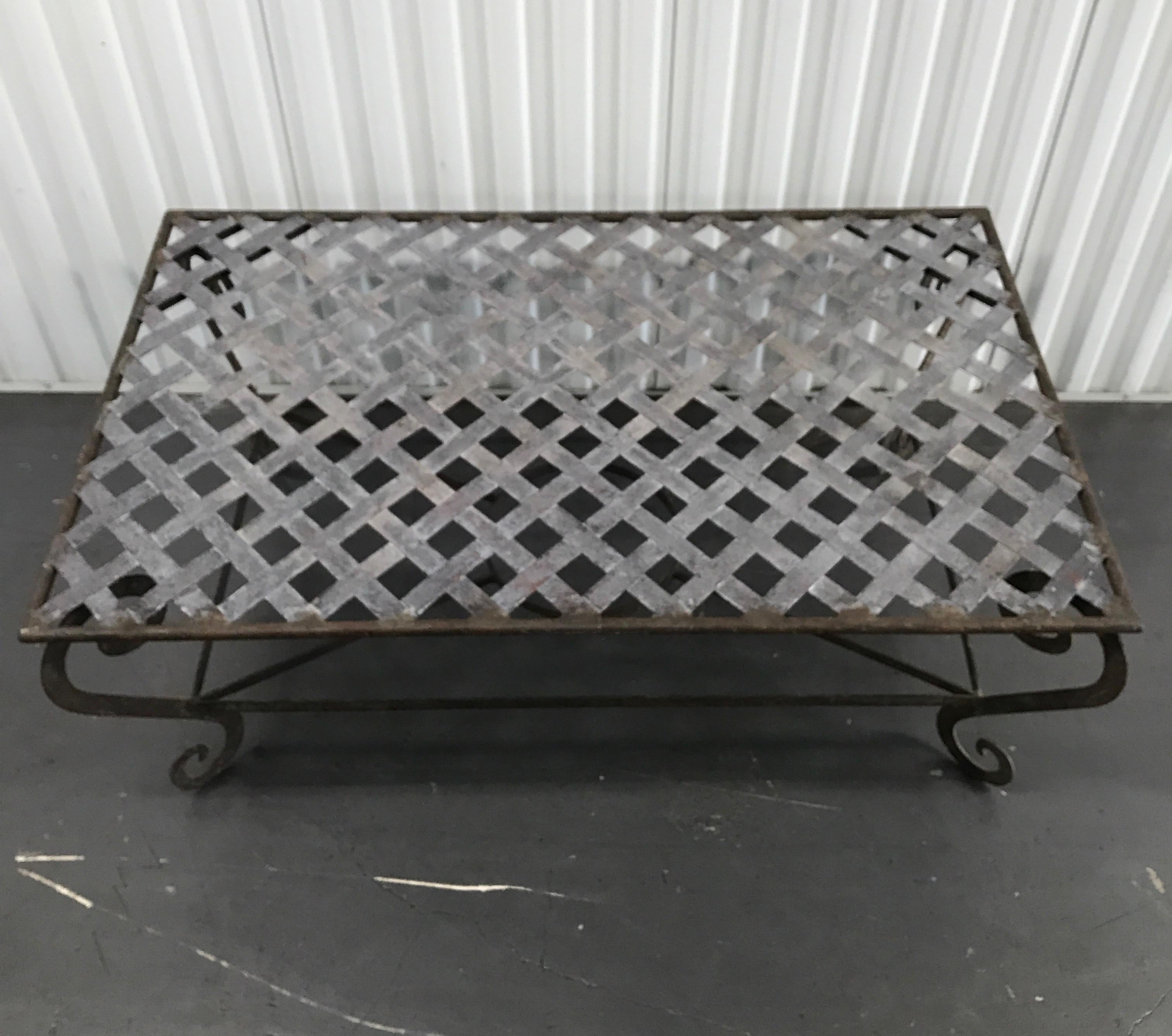 Vintage lattice top iron cocktail table with scrolled legs and original patina.