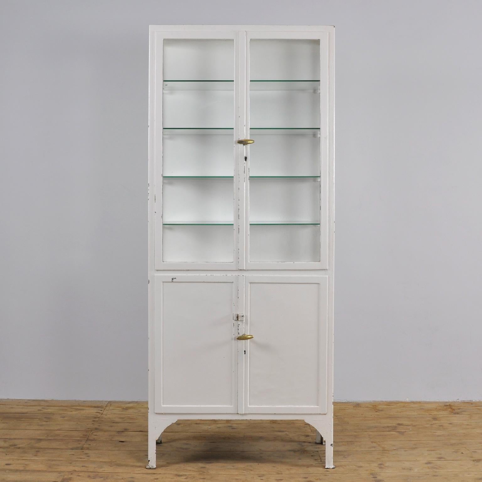 This former medicine cabinet was produced in the 1930s in Hungary. It is made of thick iron and glass. In the upper part, there are four-glass shelves.