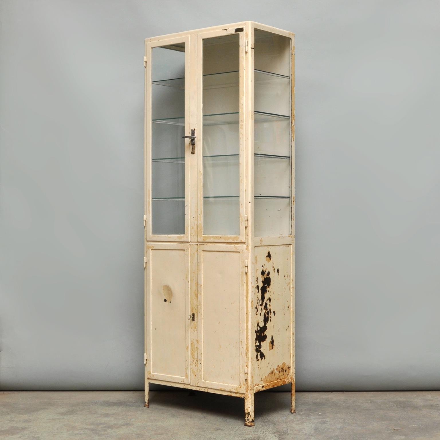Medical cabinet with character from the 1940s. Produced in the Czech Republic. In the top part four glass shelves, in the bottom part two iron shelves. The cabinet is treated against rust and finished with a transparent lacquer to fix the paint.