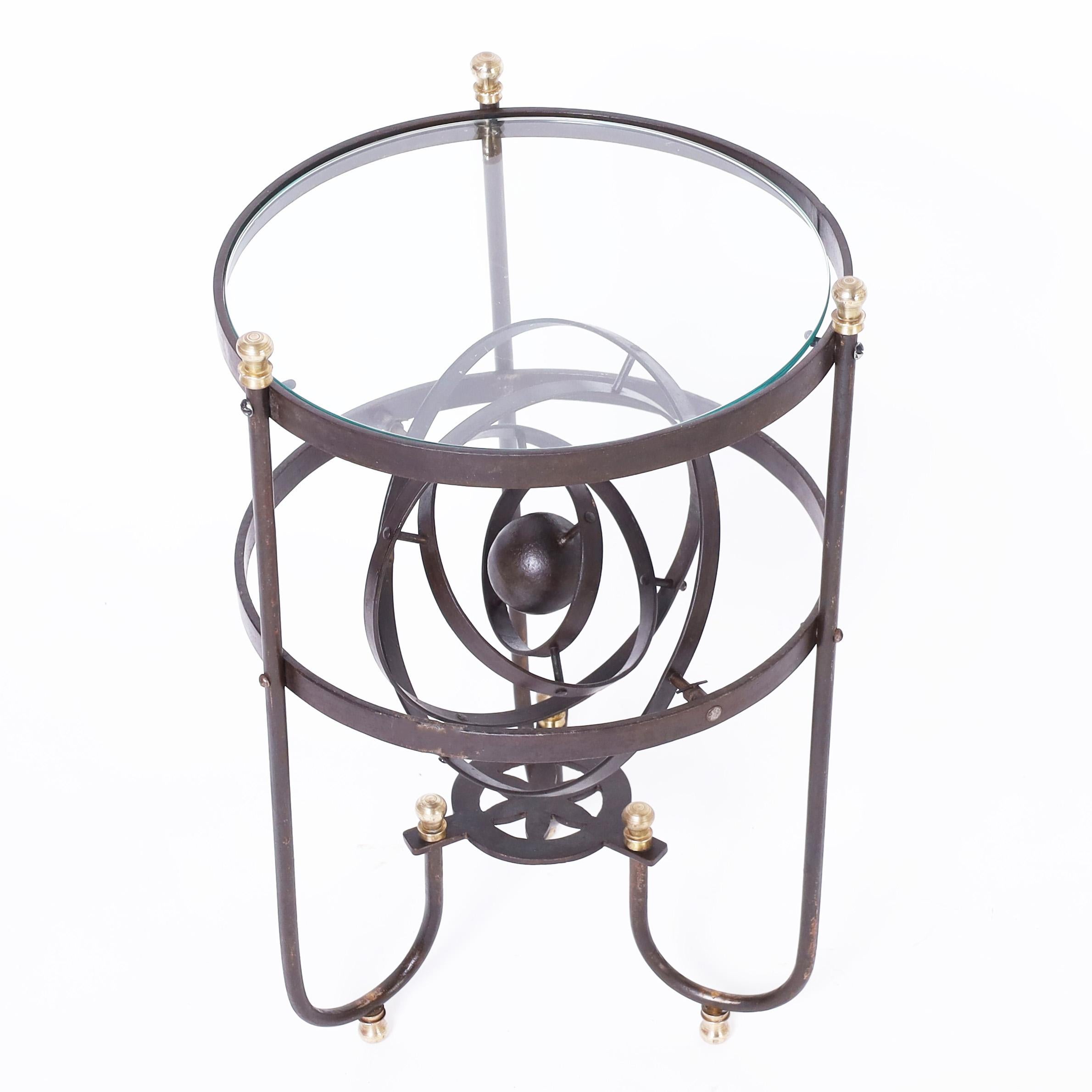 Unusual French glass top stand crafted in iron featuring a fully functioning armillary sphere and brass finials and feet. 