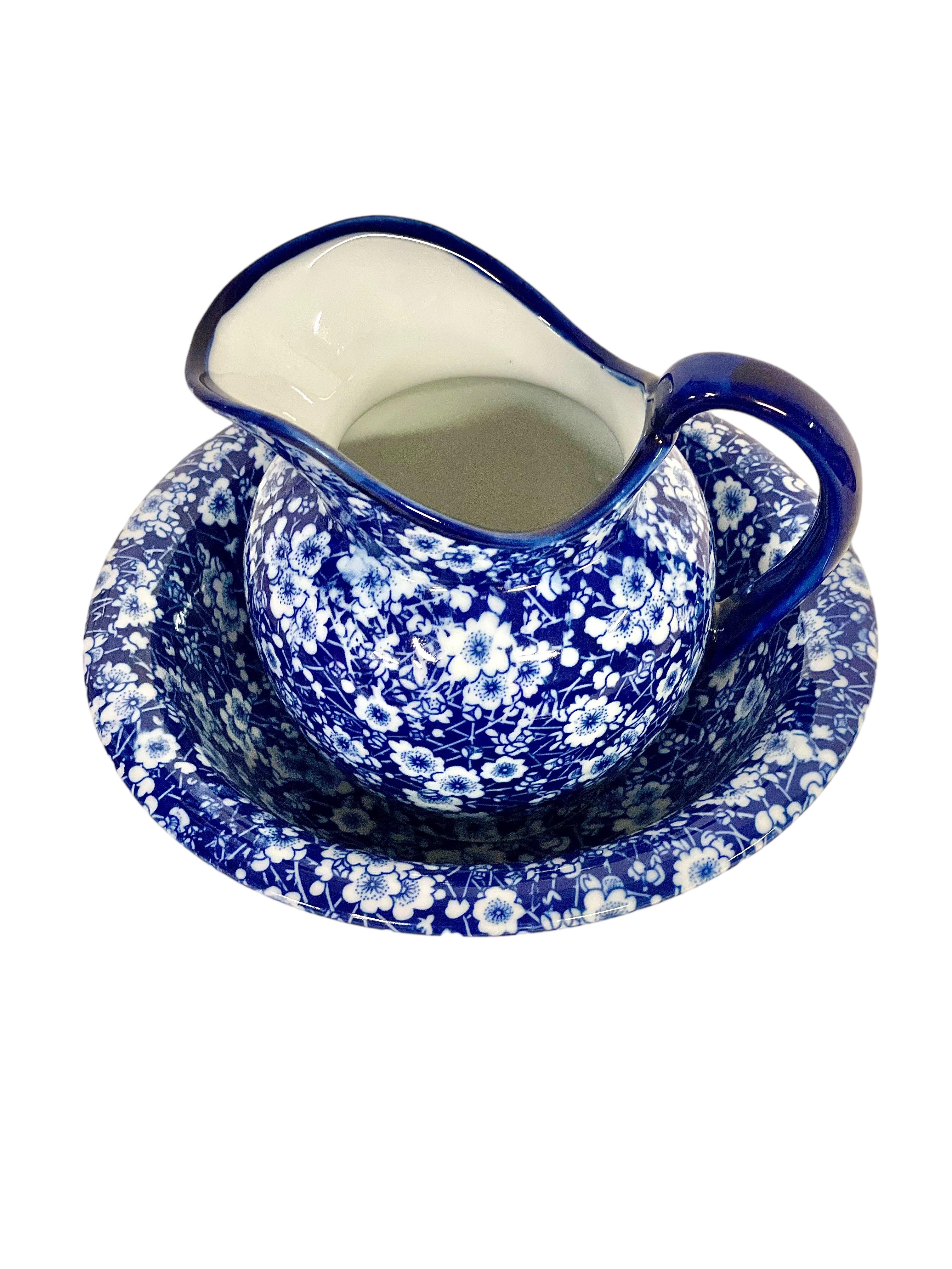 A charming vintage Ironstone pitcher and wash basin, made in England and bearing the 'Victoria Ware' mark on its base. Decorated all over in a traditional cobalt blue 'Calico' transfer pattern, this extremely pretty set would add the perfect