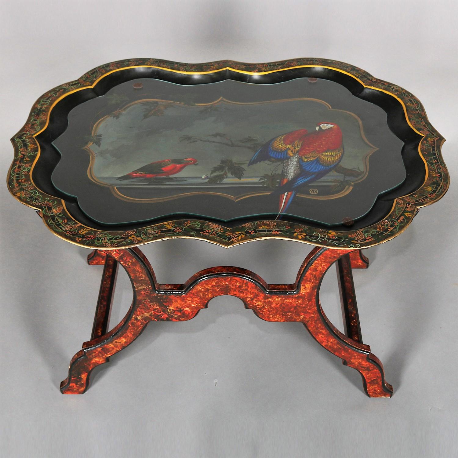 Vintage table features ebonized and gilt toleware metal tray having hand painted island scene with tropical birds (parrot and macaw) on beach with ocean and palm trees surrounded by scalloped border with foliate design and Artist-signed SD, seated