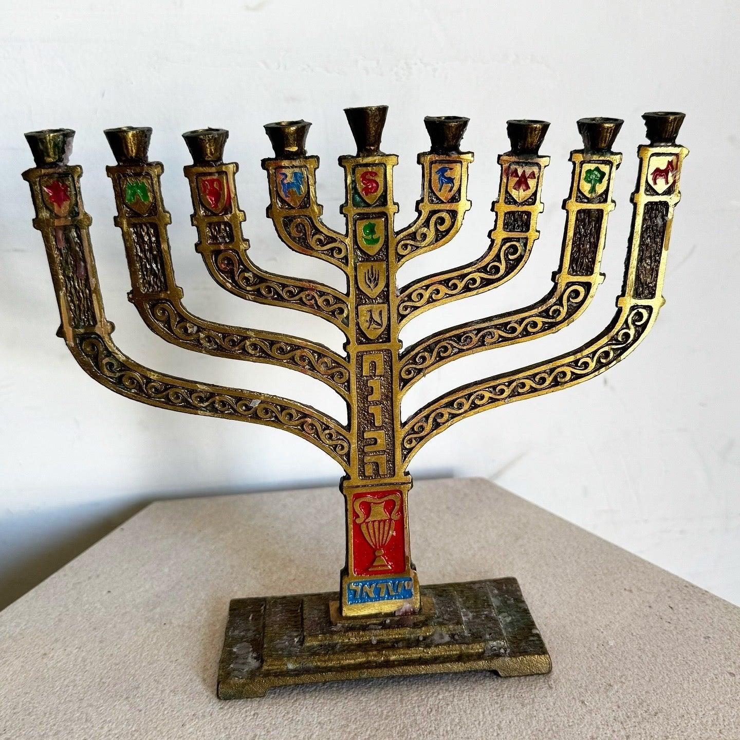 Vintage Israeli Brass 12 Tribes Menorah by Ben-Holon with hand-painted enamel and ornate filigree. Celebrate heritage with this timeless piece.
 
 We sell items as acquired, without restoring or repairing. Vintage pieces may have age-related wear.