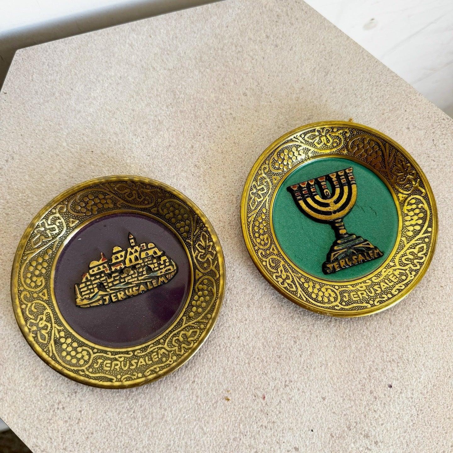 Set di due piatti decorativi israeliani d'epoca in ottone con disegni di Gerusalemme e menorah smaltati, perfetti da esporre o da collezionare.
 
 Vendiamo gli articoli così come sono stati acquistati, senza alcun restauro o riparazione. I pezzi