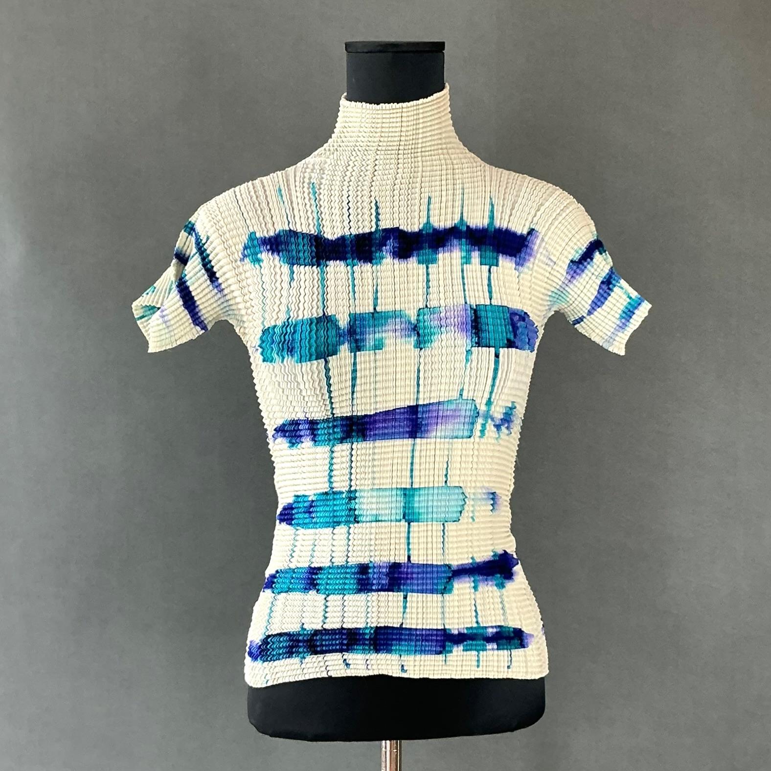 A Vintage Issey Miyake Pleats Please Tie Dye T Shirt Blouse would be a beautiful example of the innovative and avant-garde style that the renowned Japanese designer is known for. Issey Miyake revolutionized fashion with his pioneering use of
