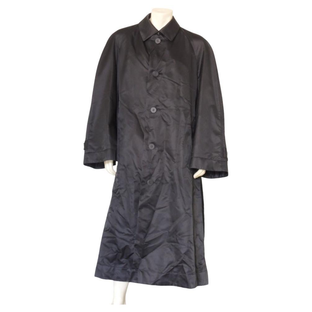 Iconic Issey Miyake Men black oversized trench / windcoat. I believe this is 1980s or 1990s era. 5-button front. Nylon exterior with rayon lining. Made in Japan.

The coat is in good vintage condition. There are no stains, no structural flaws. All