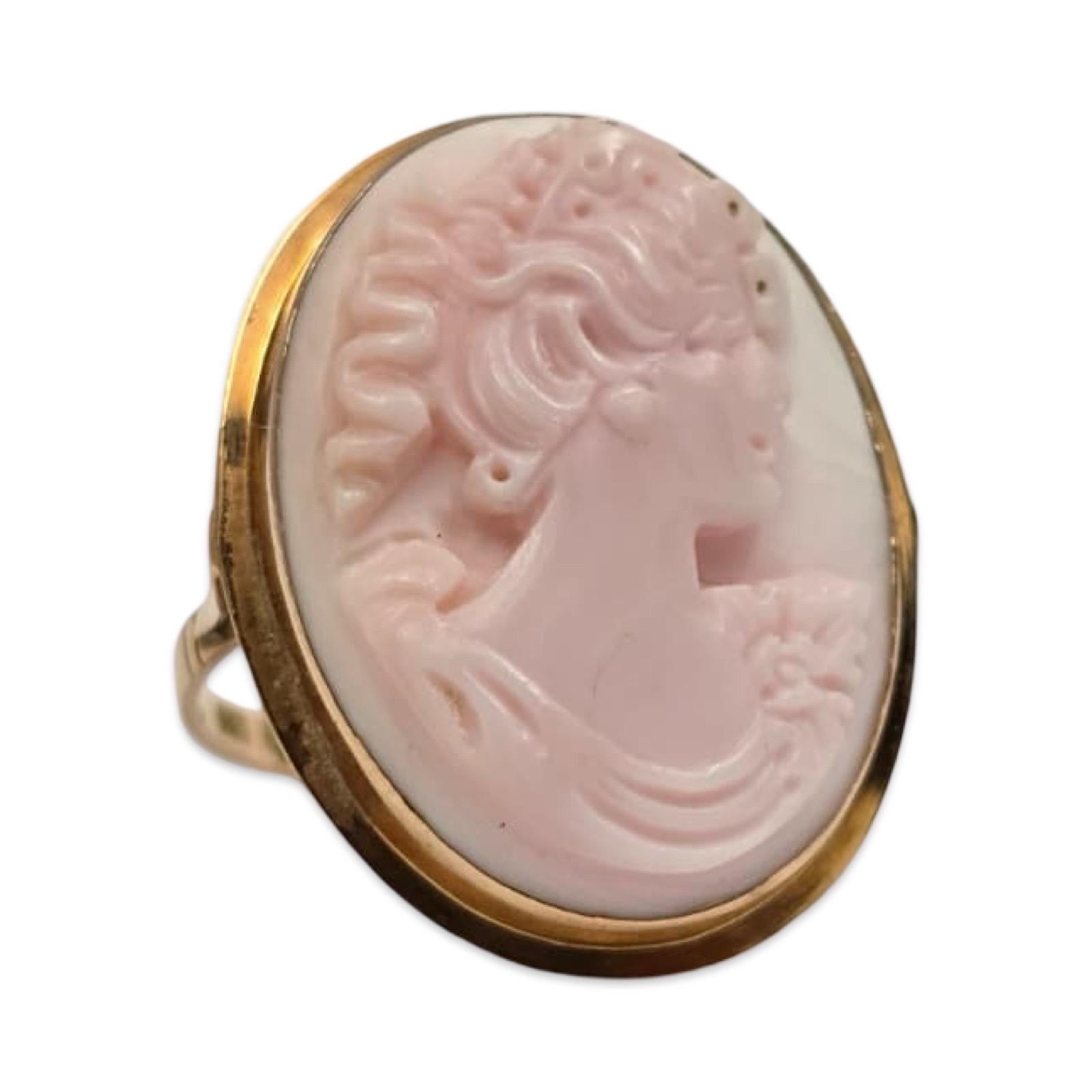 Un romantico anello cammeo italiano vintage, intagliato a mano in una morbida conchiglia arrossata e incastonato in oro massiccio 14 carati. Caratterizzato da un profilo femminile classico finemente dettagliato con capelli fluenti e motivi floreali,