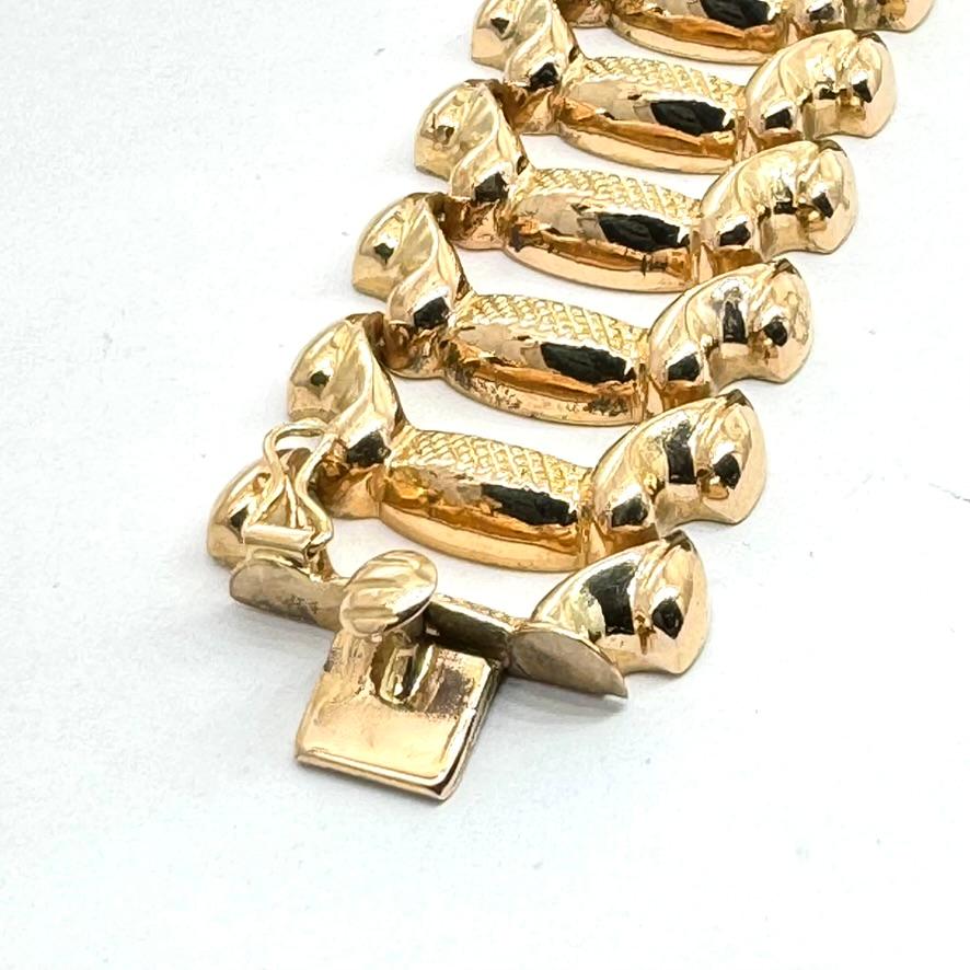 Beautifully crafted 18 carat yellow gold bracelet, made in Italy. The design features a row of scrolling leaf type motifs with Florentine finished bars, individually hinged. Integrated slide lock clasp and figure of eight safety closure. 
Bracelet