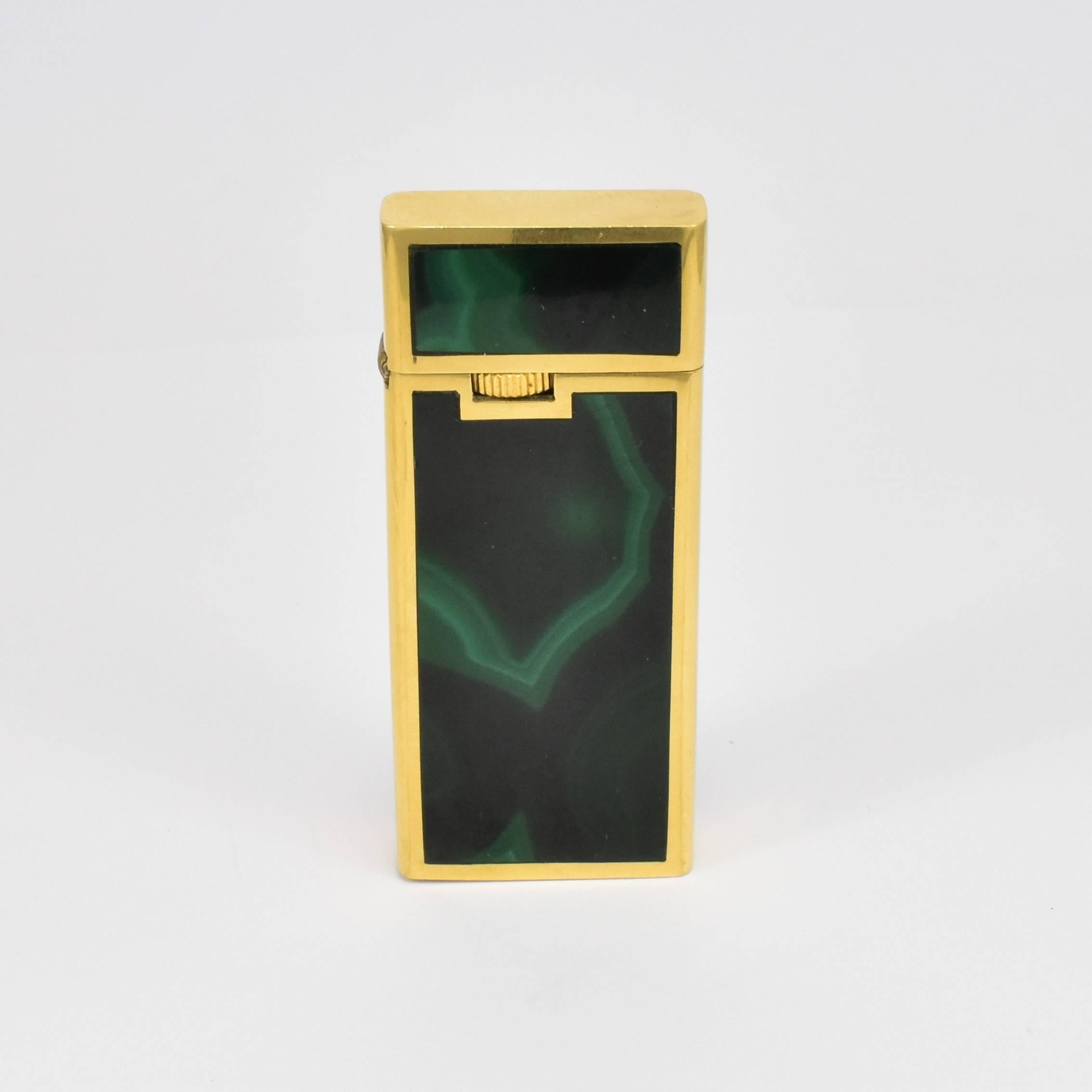 Ce briquet des années 1960 d'une facture immaculée en or jaune (testé comme tel) de 18 carats est incrusté de malachite soigneusement sélectionnée et polie. Pesant 52,58 grammes. Cette pièce de collection ultra stylée fonctionne avec un briquet à