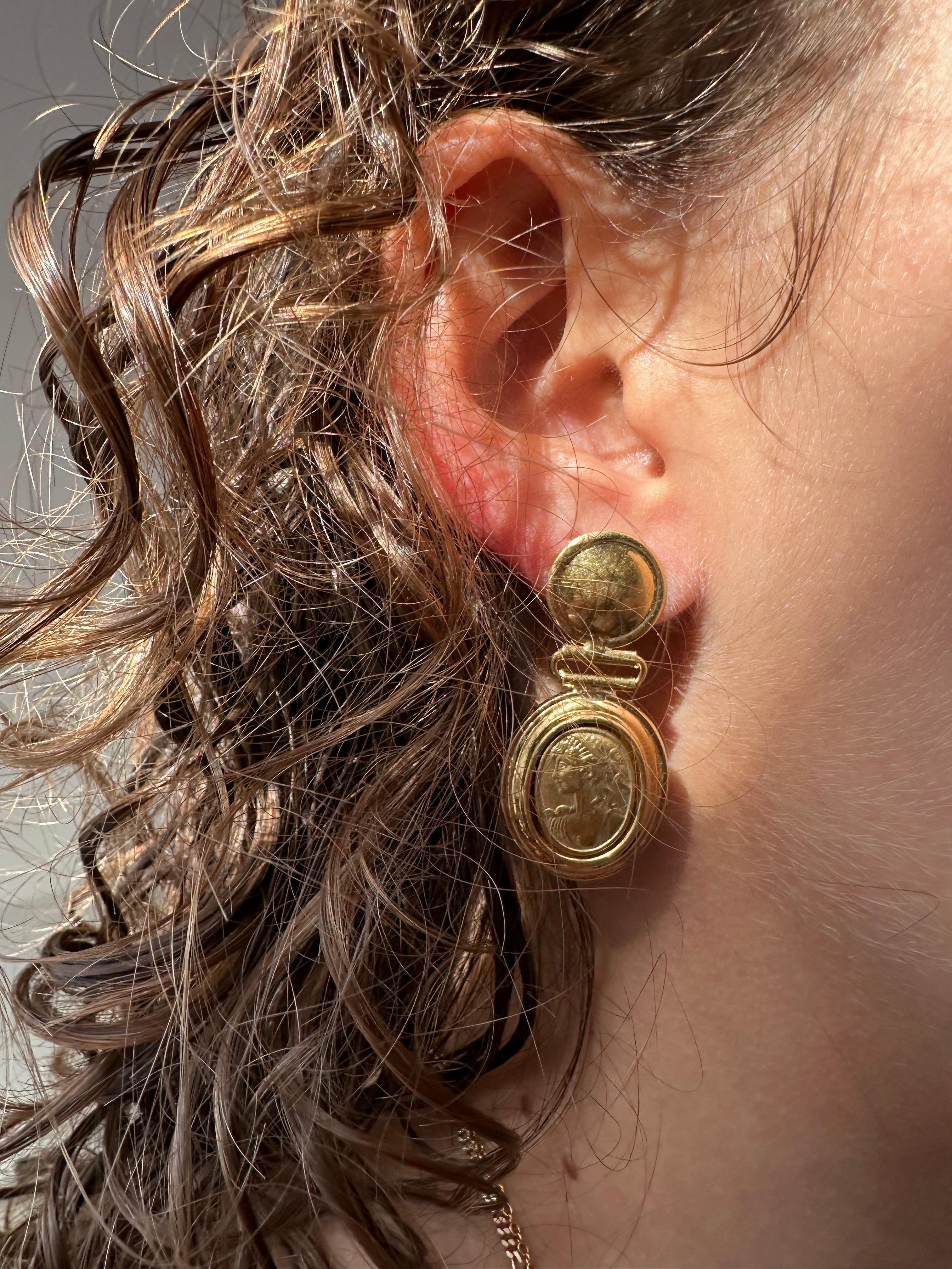 Estos Pendientes Camafeo Italianos Vintage son una representación atemporal de la elegancia clásica, elaborados en oro amarillo de 18 quilates con meticulosa atención al detalle. Diseñados como pendientes colgantes, presentan camafeos tallados a