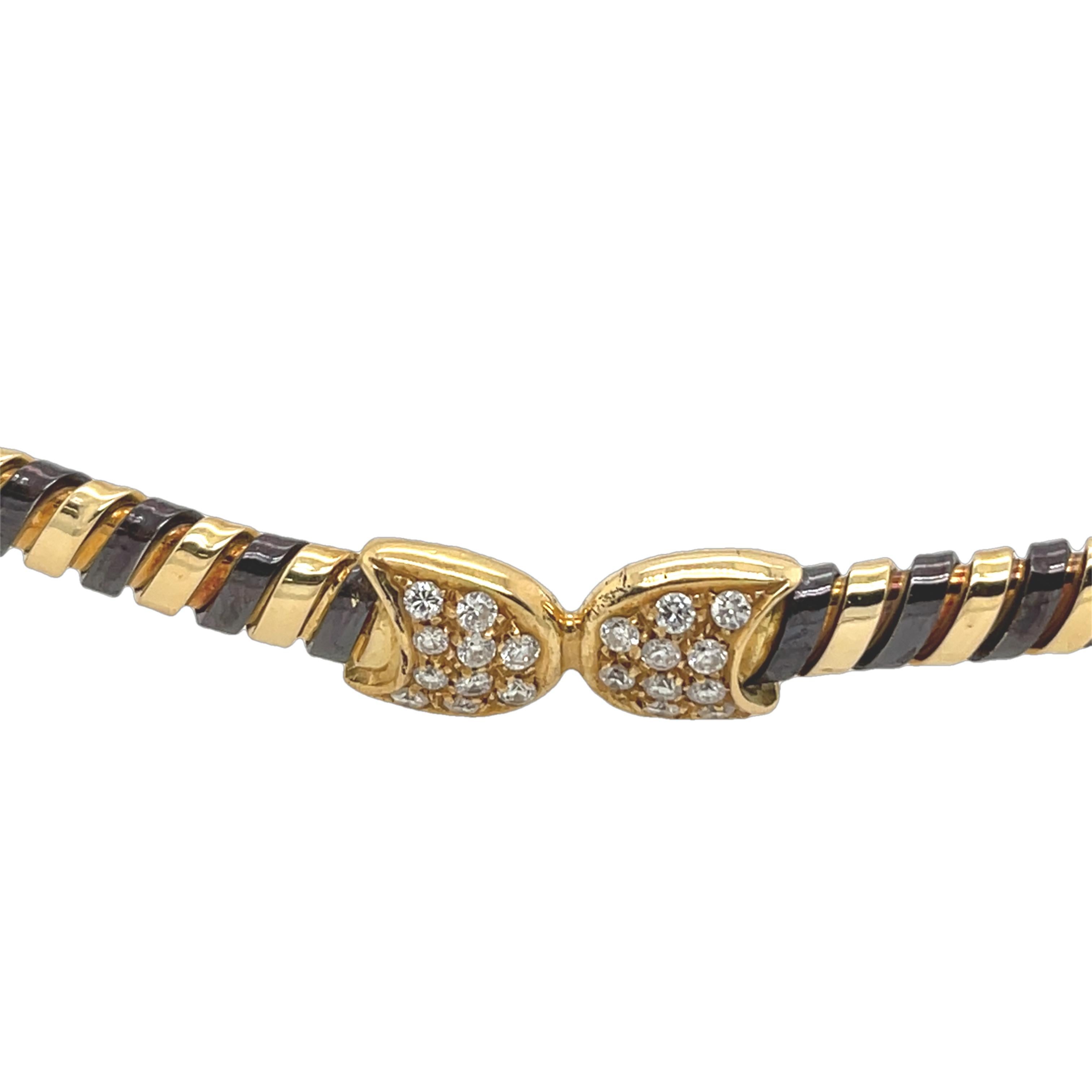 
Ce collier italien vintage présente une étonnante combinaison d'or jaune 18ct et d'acier poli, 
alliant l'élégance à l'artisanat moderne. Ornée de diamants naturels d'une valeur totale de 0,40ct pour plus de brillance, elle offre un design