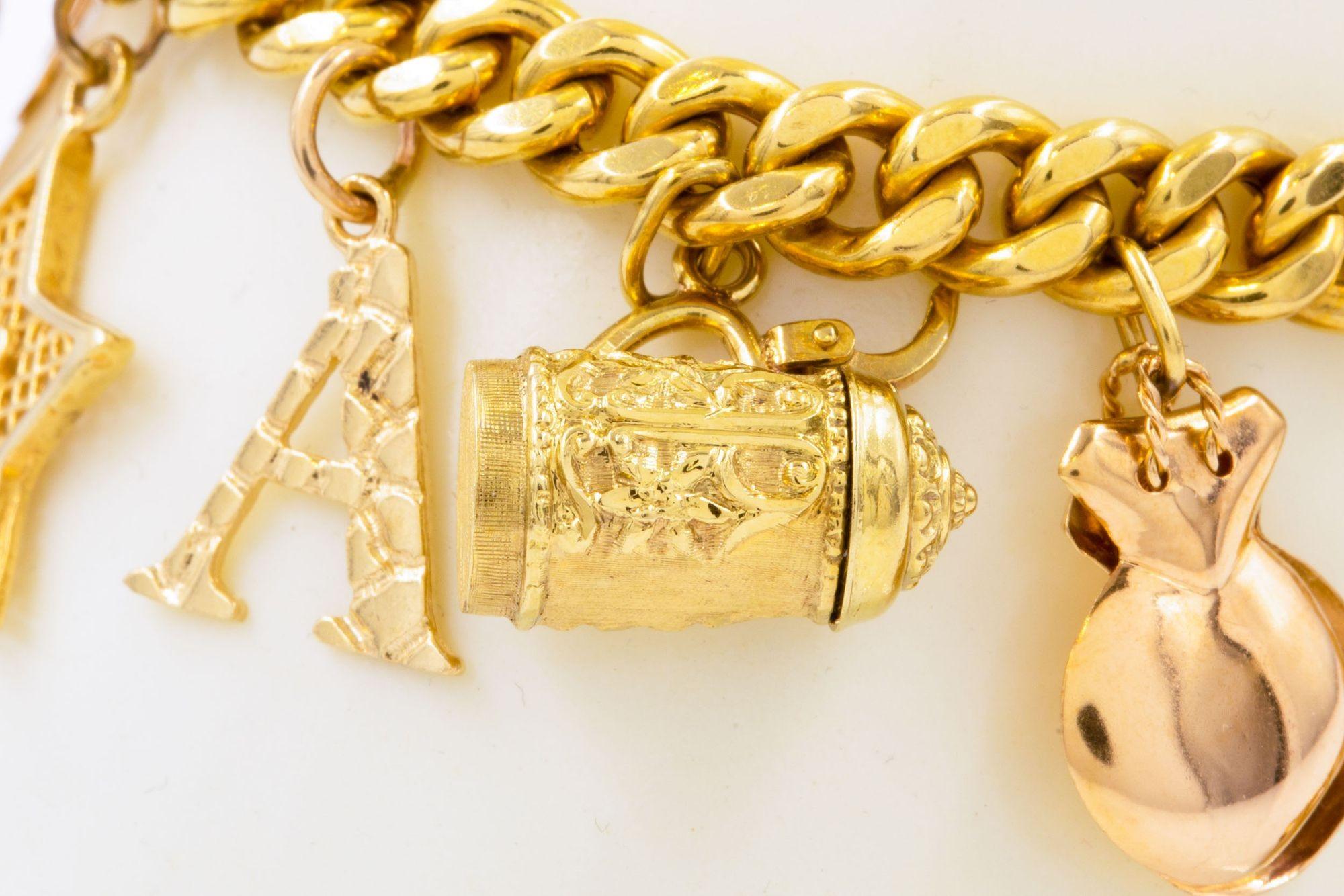 An attractive and substantial vintage 18 karat gold cuban-link bracelet with a series of included 14 karat gold charms: a house (the floor of which can be opened to reveal the hollowed interior and a pair of red hearts), the Spanish Cross with an