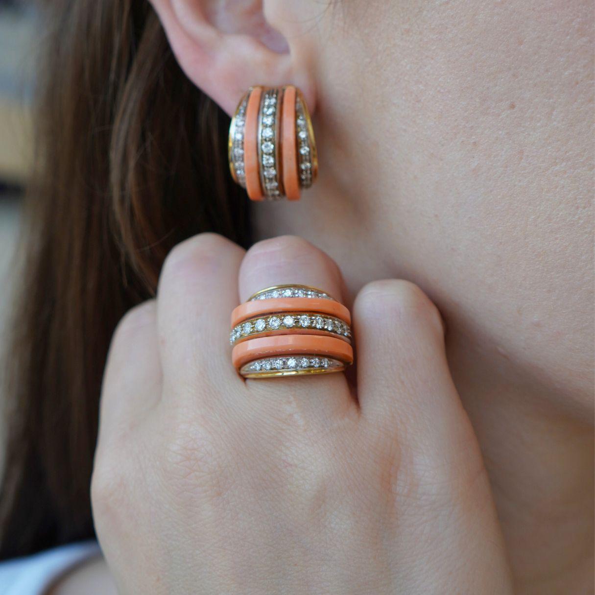 Questo anello vintage italiano è realizzato in oro giallo e bianco 18 carati e presenta un'accattivante combinazione di corallo e diamanti. Il design audace consiste in tre file di diamanti rotondi con taglio a brillante incastonati tra intarsi di