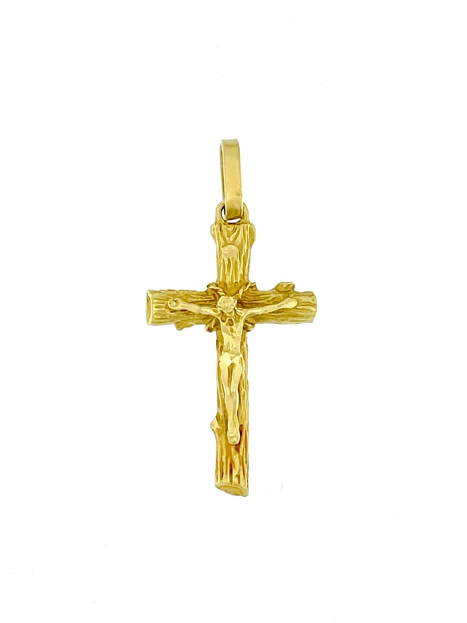 This Vintage Italian Crucifix is a captivating piece of religious jewelry crafted from lustrous 18-karat yellow gold. The crucifix stands out with its unique and intricate relief work, skillfully executed to resemble the texture of a tree trunk. The