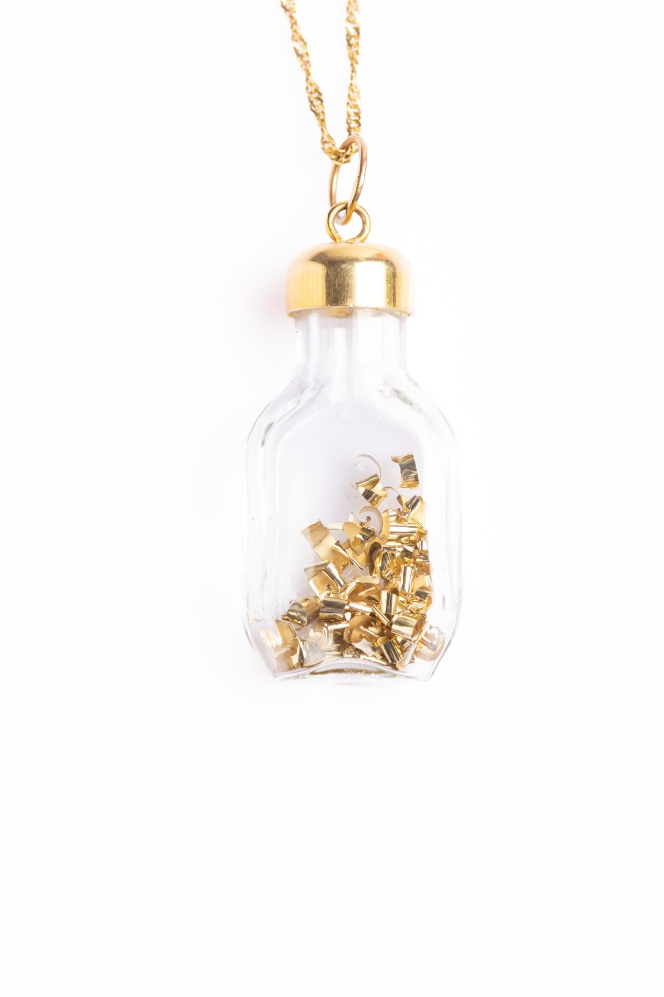 Magnifique pendentif vintage en or 9ct pour bouteille en verre remplie de paillettes d'or, complété par une chaîne en or 9ct. La chaîne et la bouteille sont poinçonnées pour de l'or 9ct et estampillées 