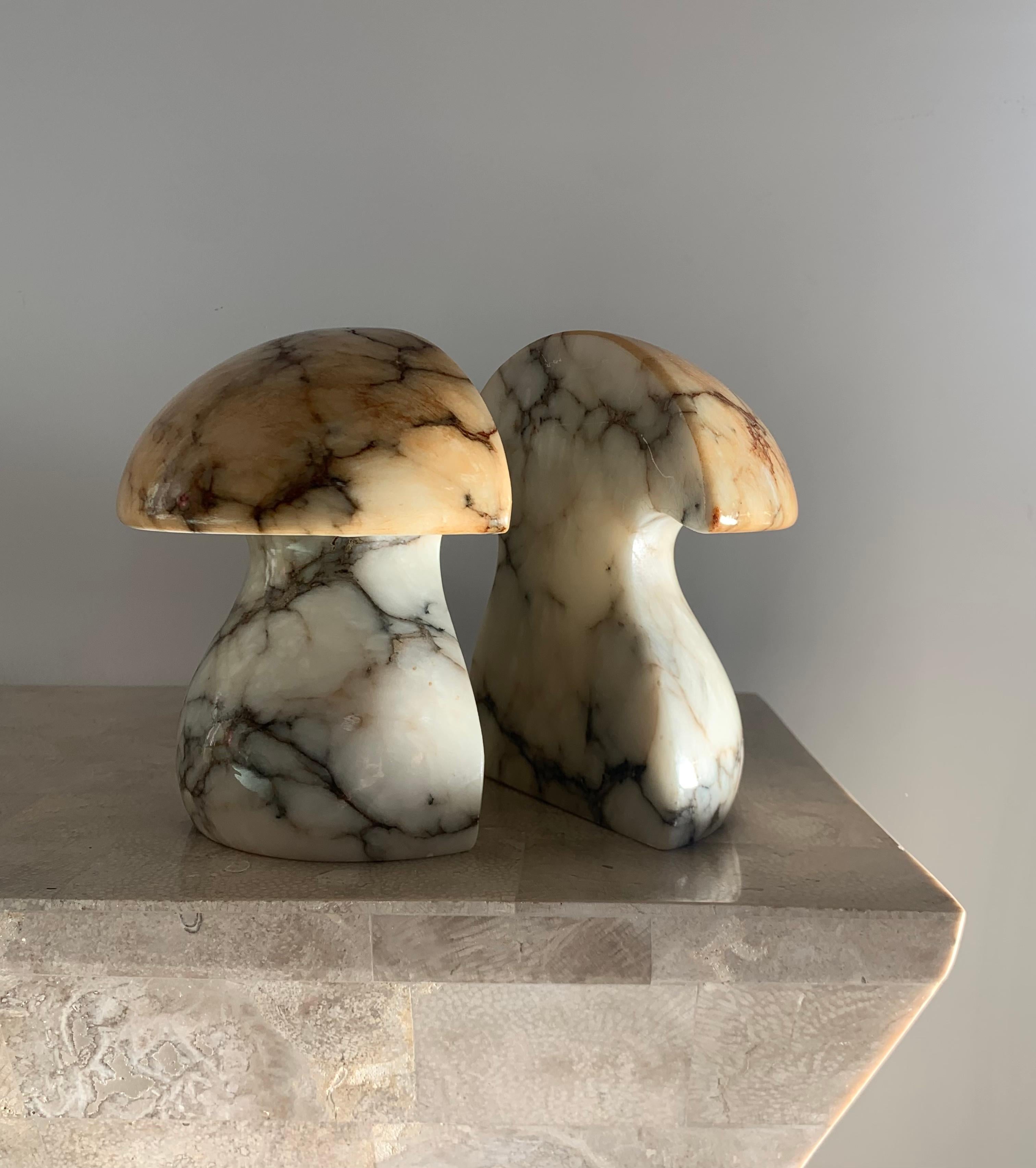 ABF marble mushroom bookends, 1960s. Curvy ivory stem with pale coral caps and ashen burgundy veining throughout. A blemish on one of the bookends reveals a minor loss that has been repaired; otherwise fabulous condition with petit signs of age. A