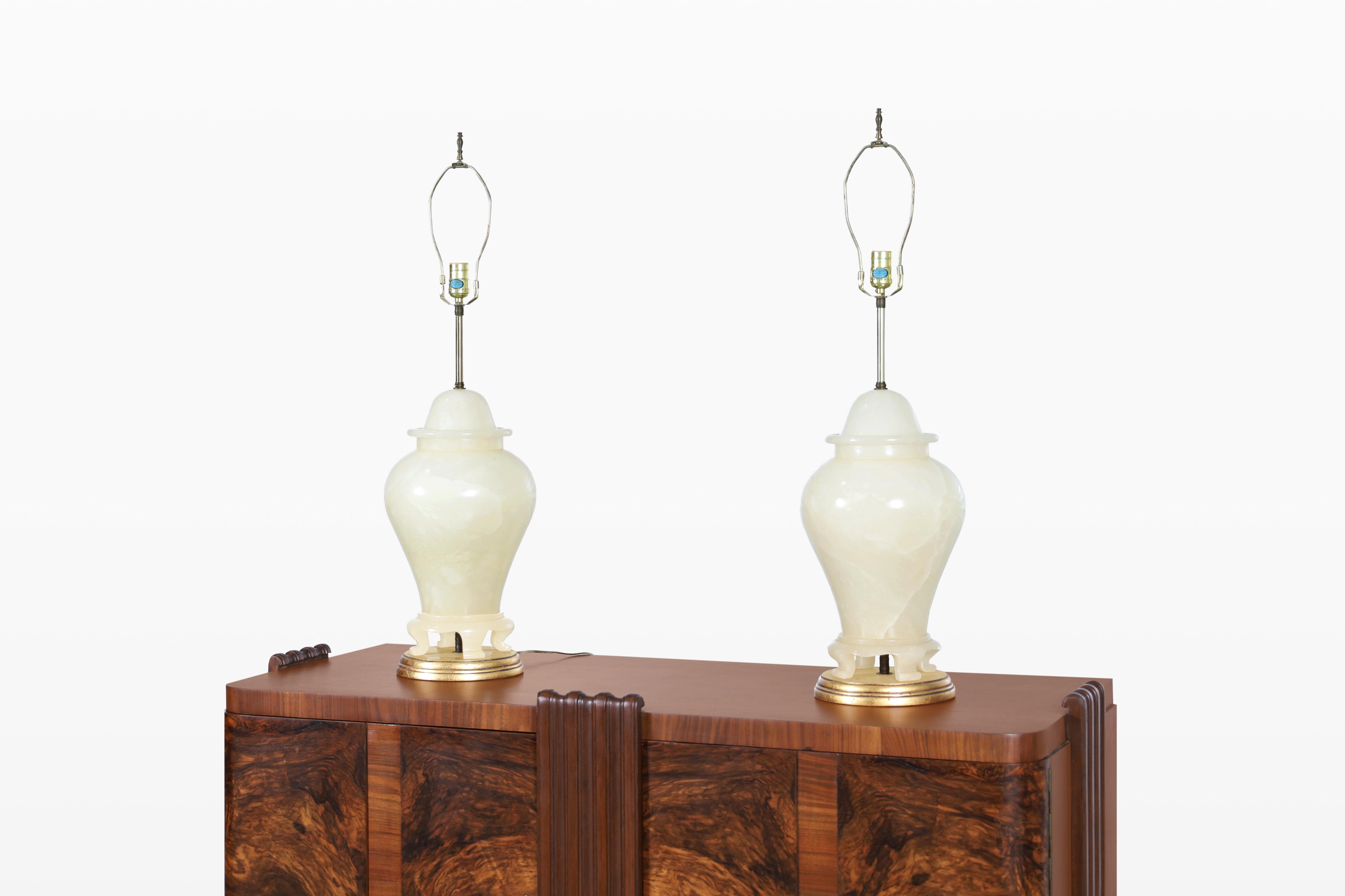 Un impresionante par de lámparas de mesa italianas vintage, diseñadas en la década de 1960, que encarnan la sofisticación y el encanto atemporal. Fabricadas en exquisito alabastro, estas lámparas presentan una superficie pulida que se complementa