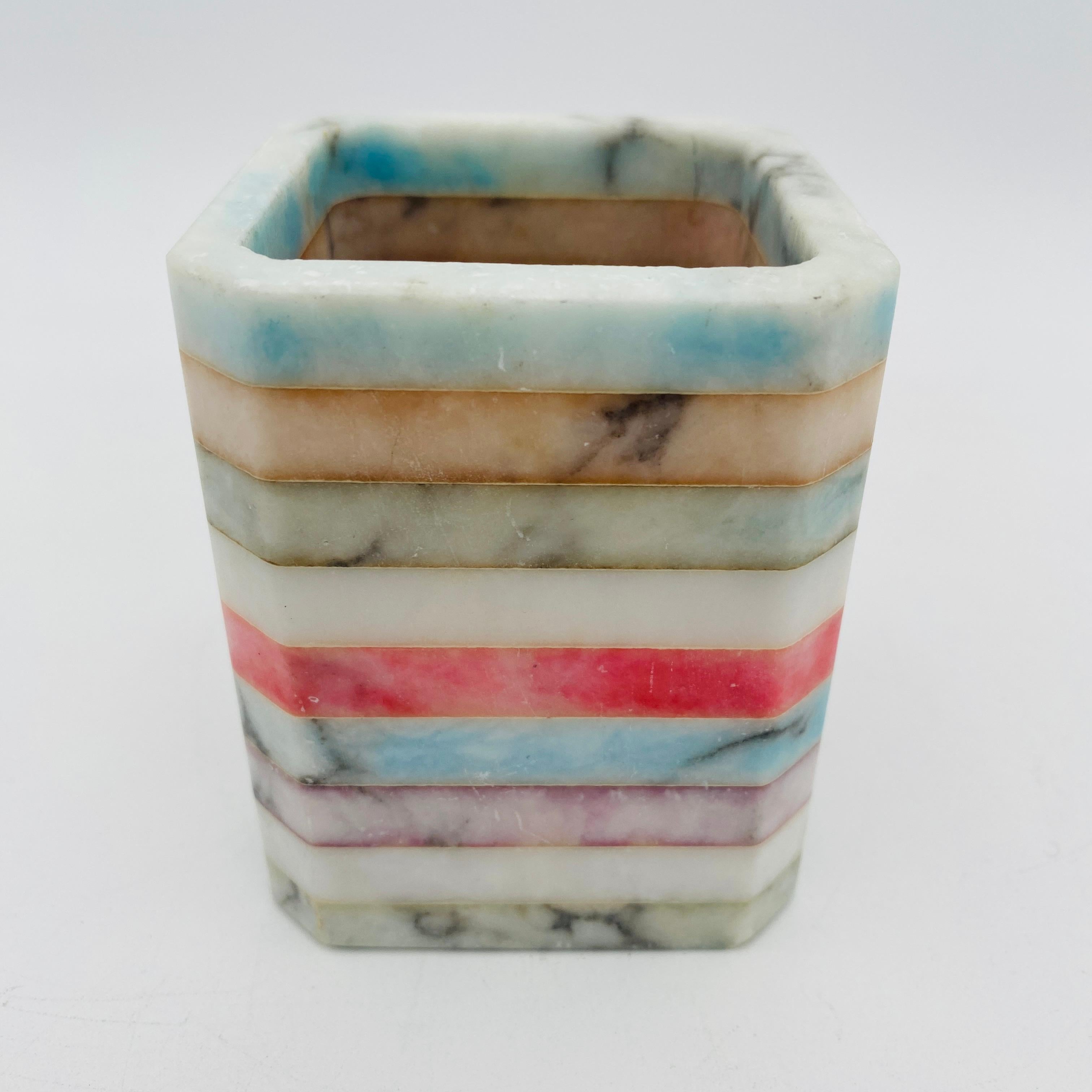 Bicchiere arcobaleno colorato realizzato in pietra alabastro italiana. È un accessorio perfetto per la casa per contenere matite, penne, forbici, ecc. Il fondo conserva l'adesivo originale con la scritta 