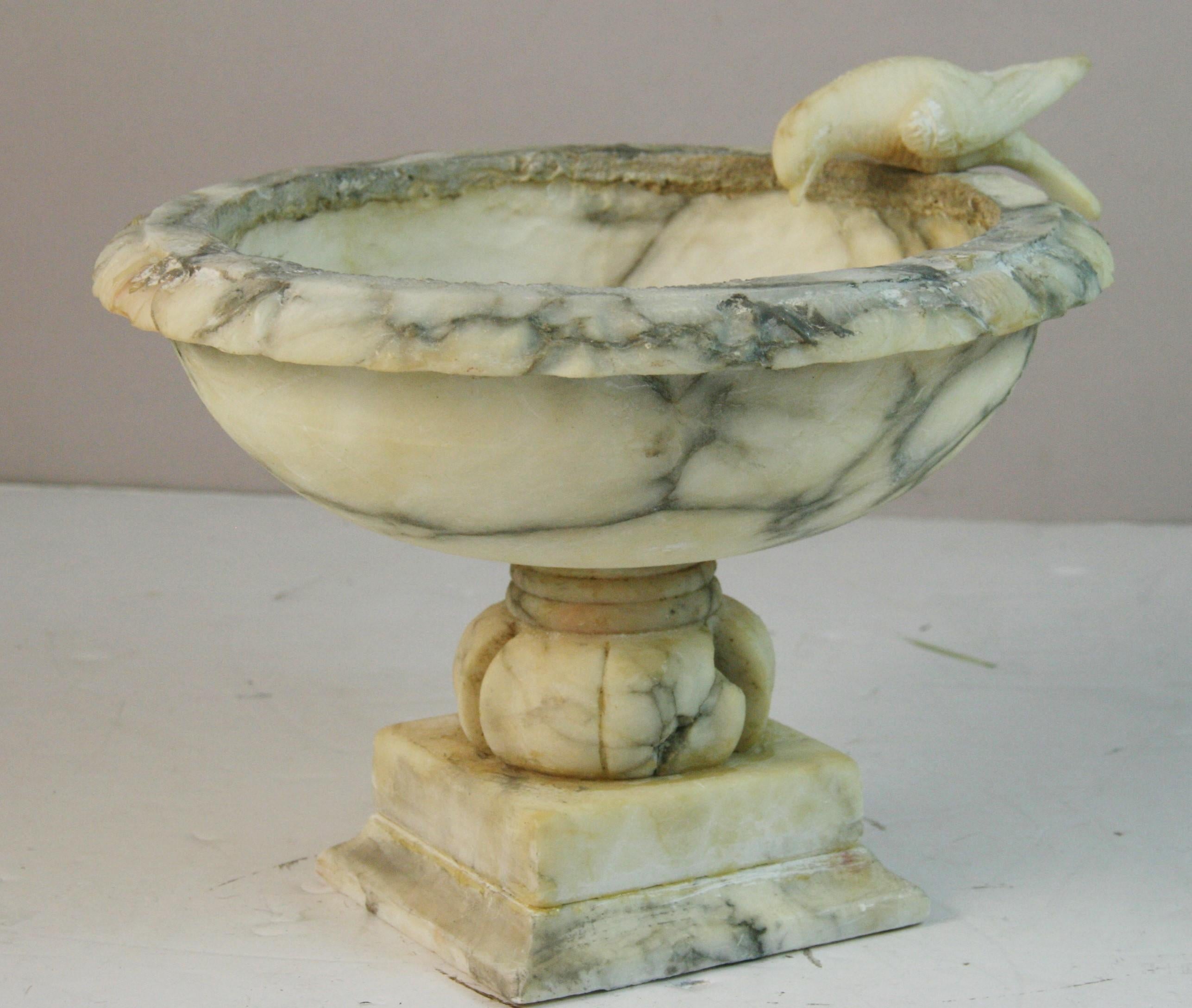 1857 An Italian Vintage alabaster tazza.fruit compote bowl , catchall vide-poche ,etc. With a carved bird on the rim
Elaberate pedestal base
Piece is predominantly white with gray/black piening.