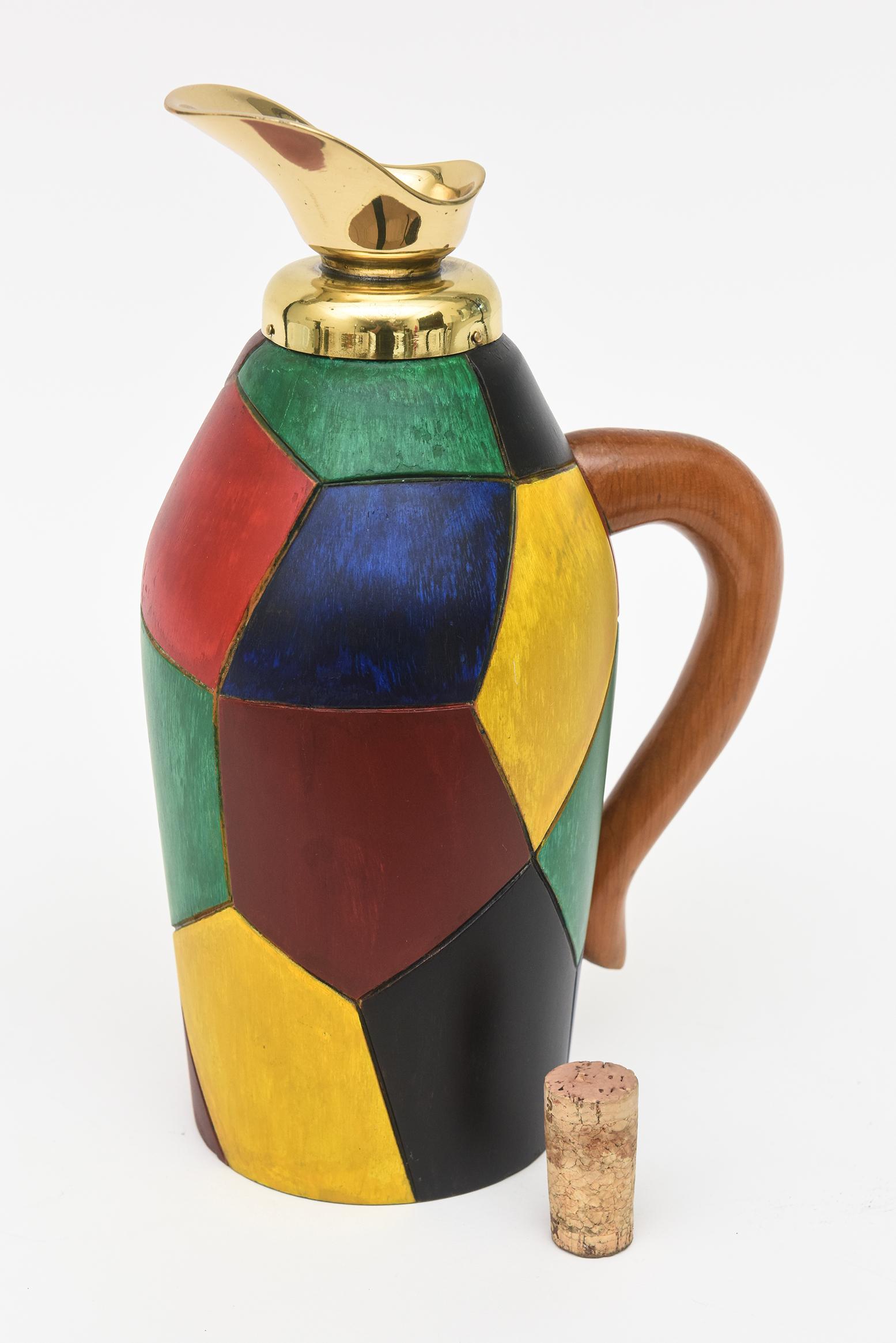 This fabulous mid century modern Italian Aldo Tura style jug has the original color painted wood forms on the front. The colors range from navy blue, mustard yellow, emerald green, burgundy and red. The handle is the original colored wood. The brass