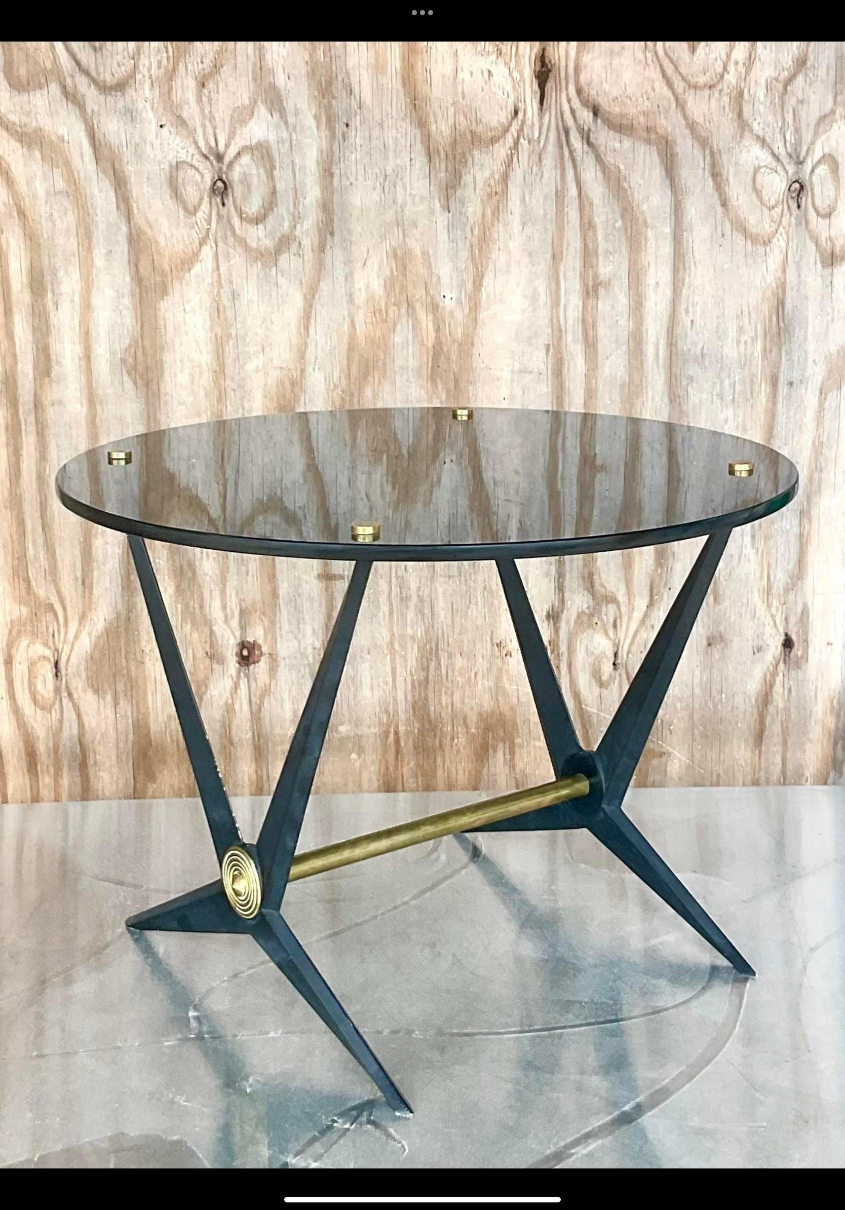 Spectacular vintage Italian cocktail table. Made by the iconic designer Angelo Ostuni. Chic cast aluminum with a black enameled surface. Smoked glass and brass hardware. A real collectors gem. Acquired from a Palm Beach estate.