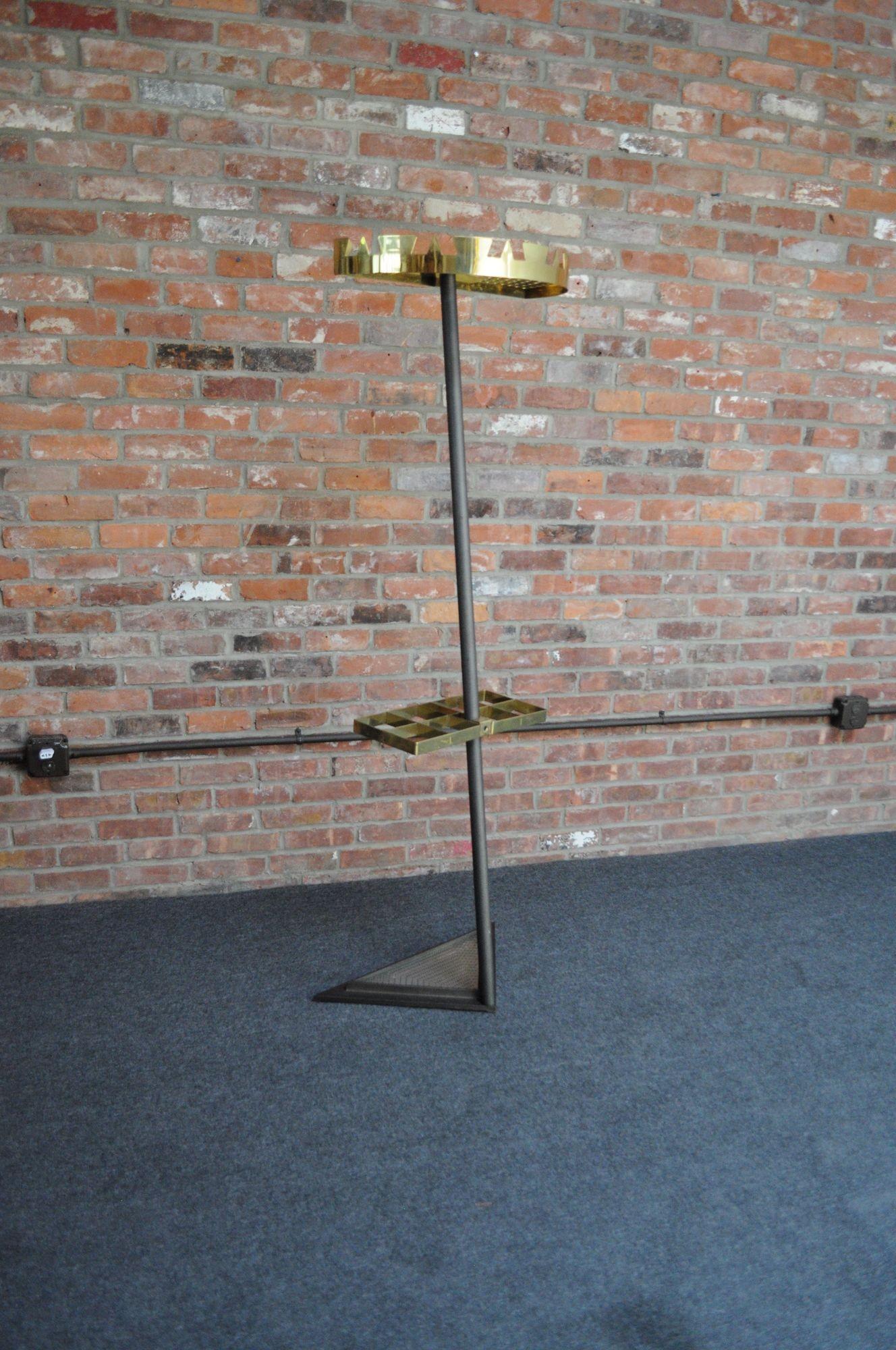 Visually stunning steel and brass slanted coat rack, ca. 1970s Italy.
Composed of an angled steel column/pole supporting a brass demilune top rack with a perforated surface and 'crown' border of cut triangular and trapezoidal 'hooks' for hanging
