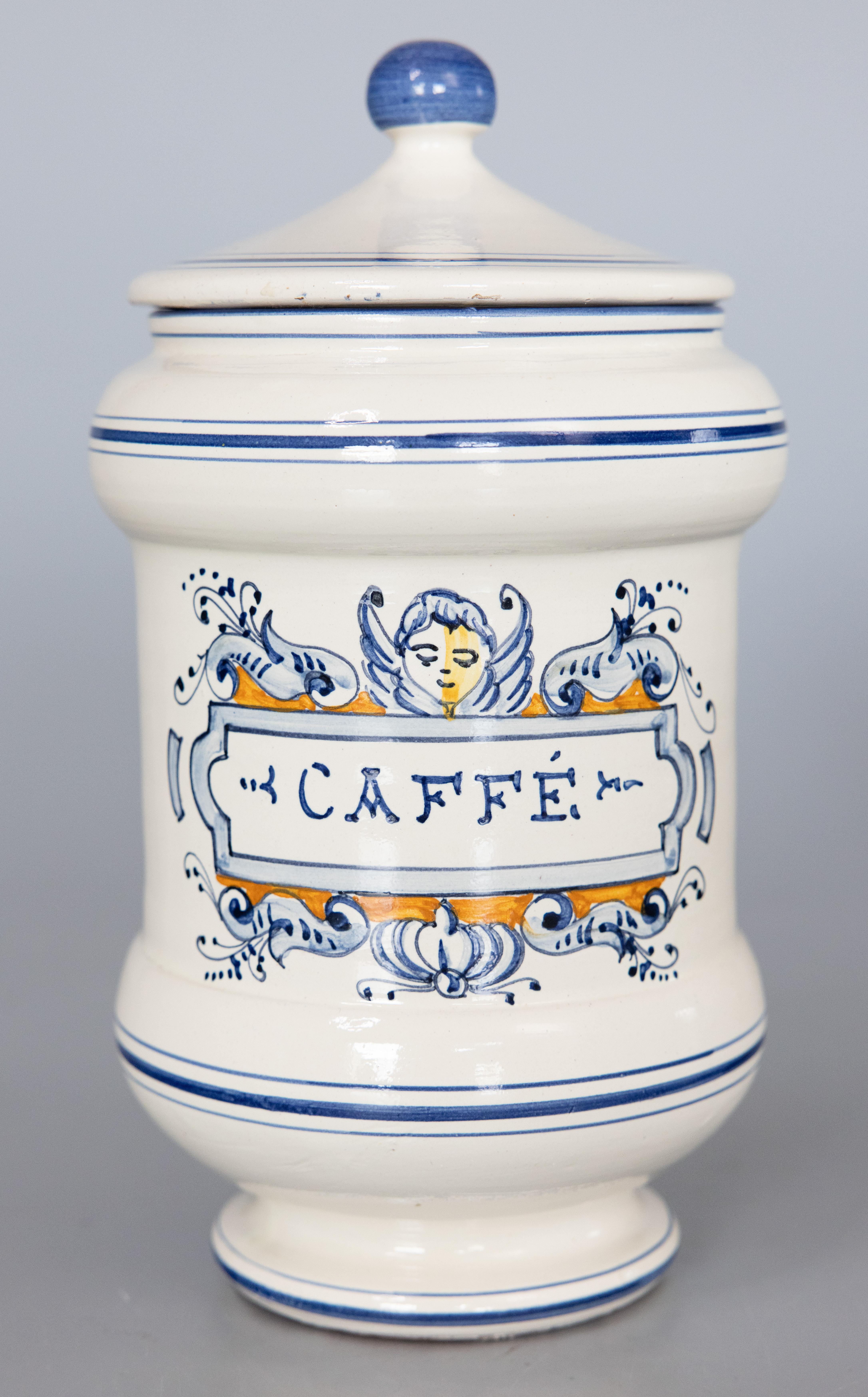 Charmant ensemble de trois pots d'apothicaire italiens à couvercle, vers 1930. Ces jolis pots sont peints à la main avec des chérubins et les noms italiens du café, de l'origan et du thé. Ils s'affichent magnifiquement, parfaits pour une cuisine ou