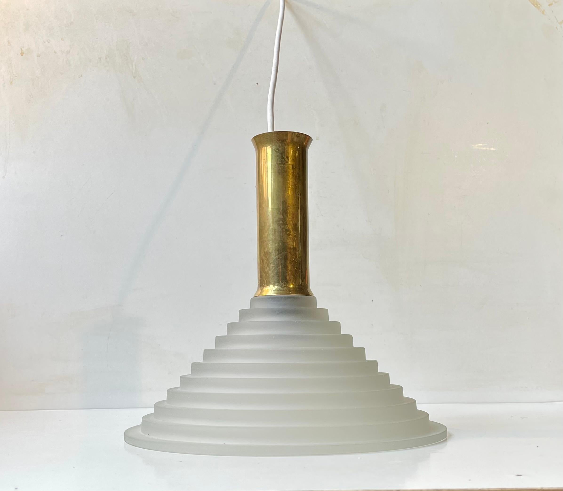 A stylish, unusual and possibly bespoke ceiling lamp composed of a frosted and architecturally 'staired' glass shade and featuring a top in solid patinated brass. Art Deco revival in style. Unknown Italian maker/design circa 1970-80. Measurements: