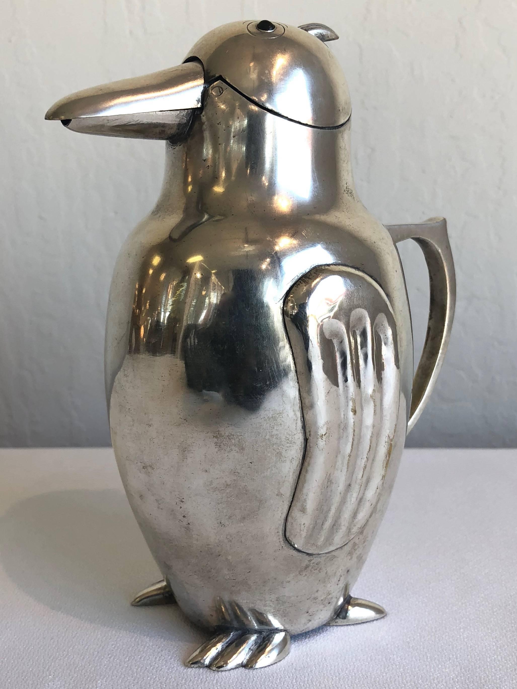 A delightful and uncommon 1930s Italian Art Deco silverplate penguin cocktail server or pitcher.

Hinged beak with hidden integrated stopper opens and closes effortlessly and automatically as it's tilted to pour. Streamlined body accented by fluted