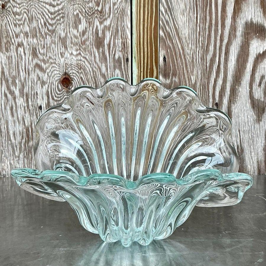 Fangen Sie den Reiz italienischer Kunstfertigkeit mit dieser Muschelschale aus Vintage-Glas ein, die vom berühmten Murano Seguso-Stil inspiriert ist. Die fließenden Linien und die leuchtenden Farben erinnern an die Schönheit der Meereswellen und