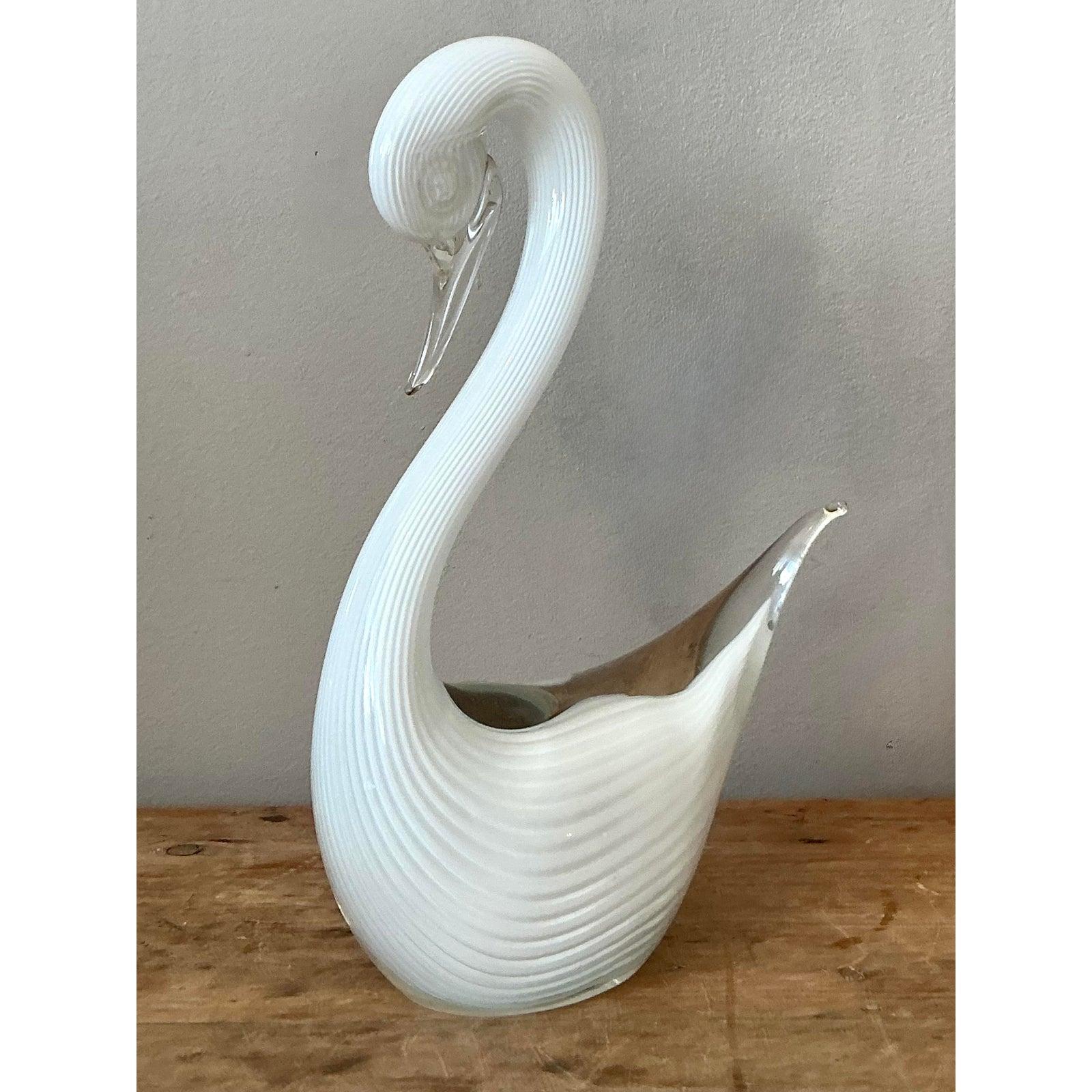 Questa squisita scultura in vetro artistico vintage cattura la bellezza lirica di un cigno con il suo collo graziosamente arcuato e la sua silhouette raffinata. Realizzato in vetro bianco opalino, il corpo e il collo sono caratterizzati da delicate