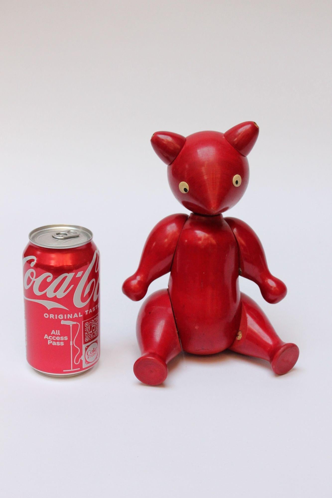 Striking red maple bear figurine with hand-painted and applied details (ca. 1950, Italy). Interior elastic and stuffing allow for articulation of limbs. Bear cannot stand on its own but can sit upright. Bold, vibrant decorative object pairing well