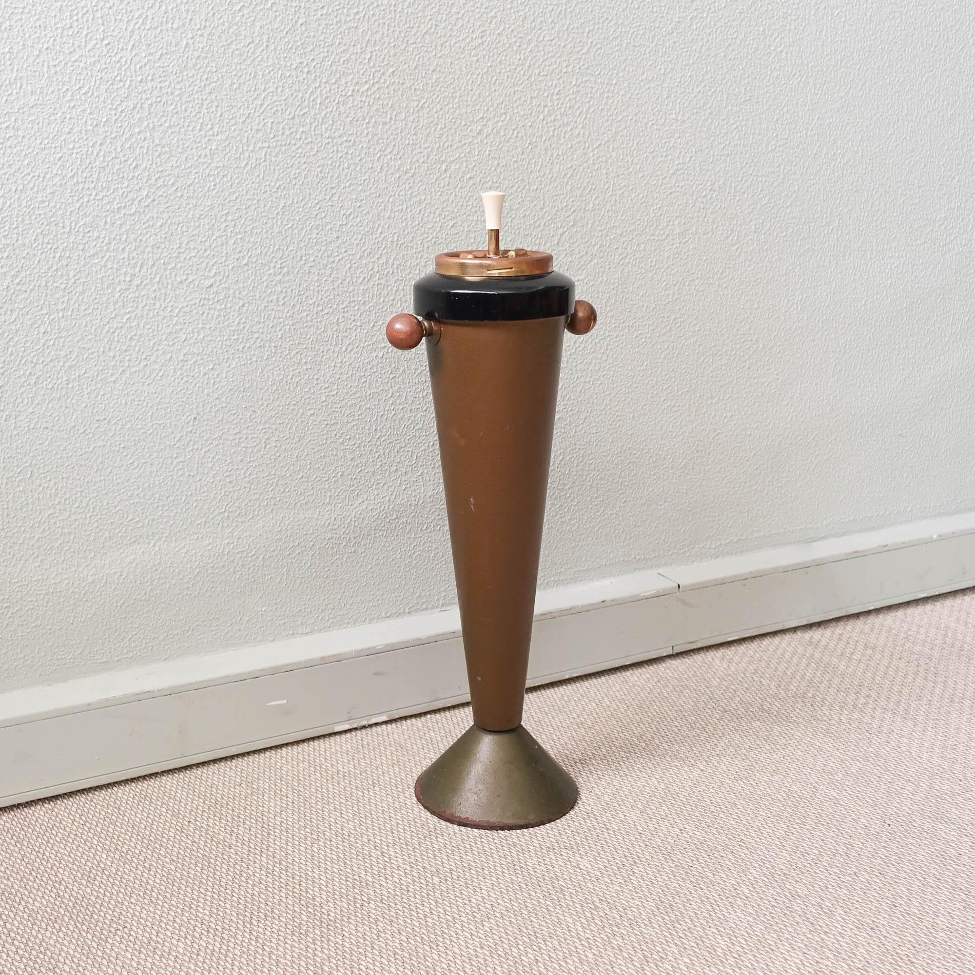 This astray was produced in Italy and is original from the 1950's. It is made of brass and iron, and on the top is the ashtray. With a conical shape and two brass handles on the sides. On top you can press the white part and the plate of the ashtray