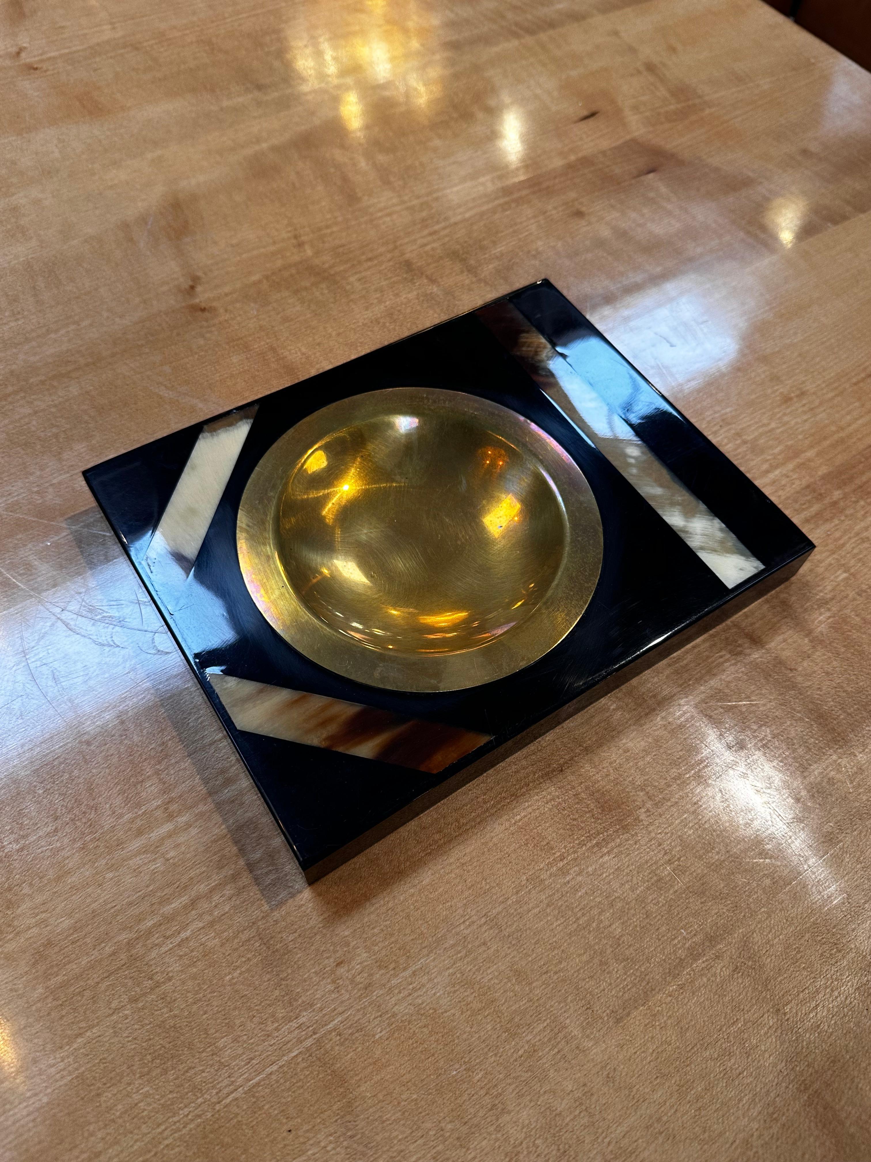 Immerse yourself in the allure of our Vintage Italian Ashtray from the 1980s, a stunning blend of sophistication and craftsmanship. Crafted in Italy, this ashtray features a harmonious marriage of brass and mother of pearl. The lustrous brass adds a